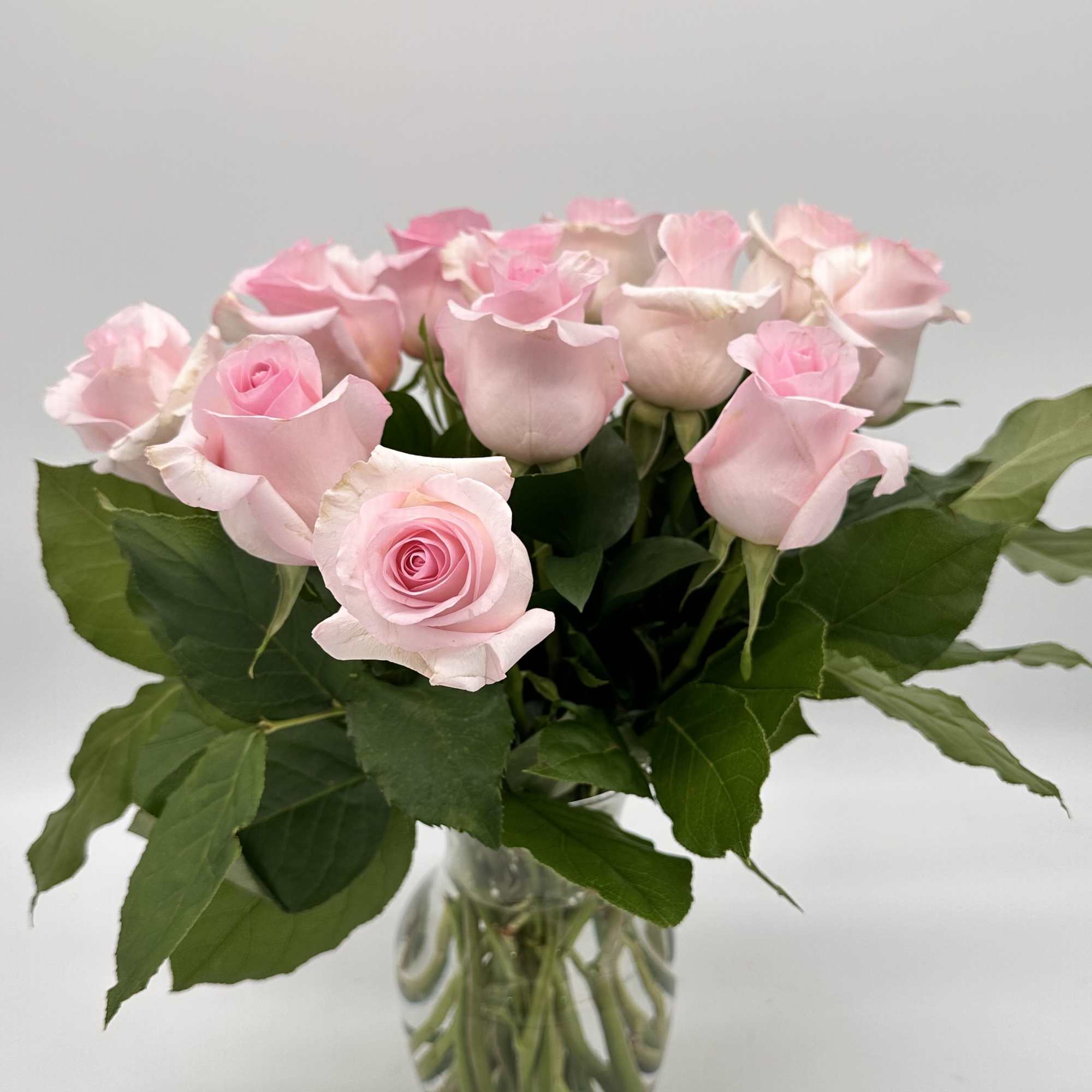 Pink roses arranged in a clear glass vase