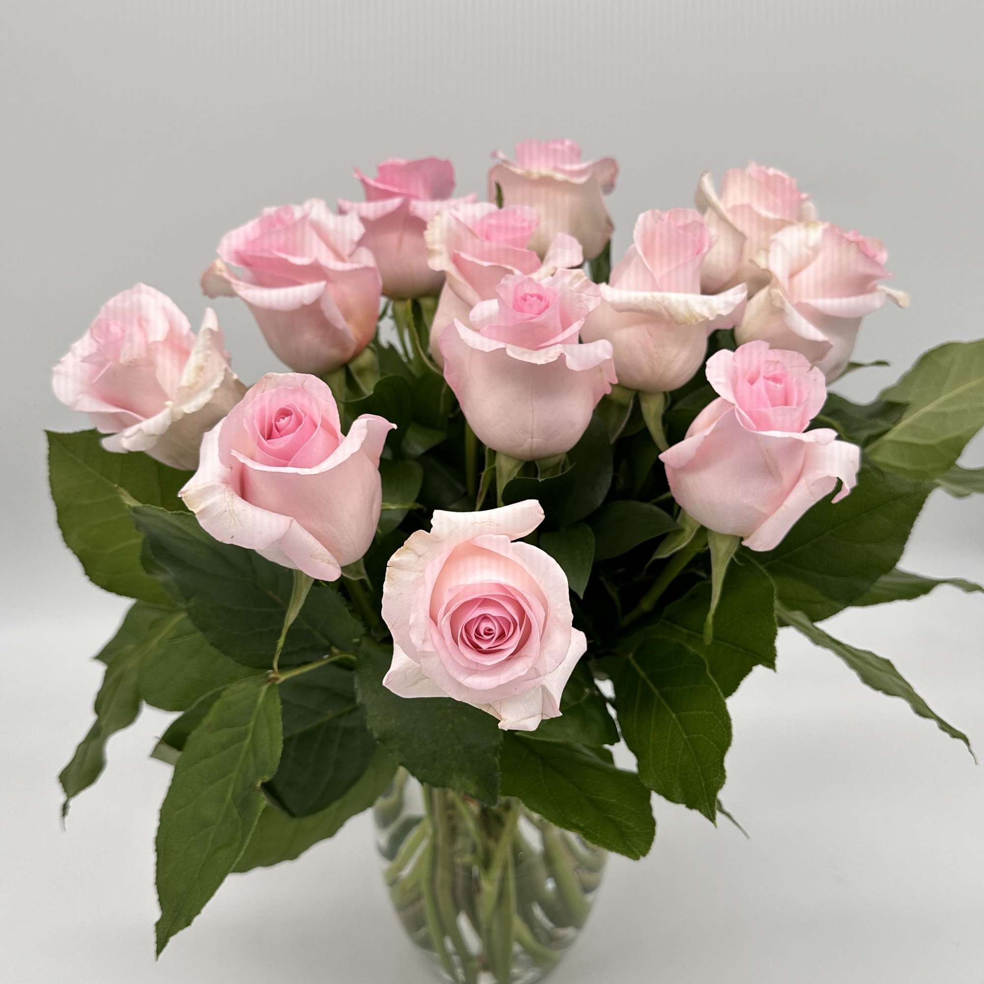 Pink roses arranged in a clear glass vase