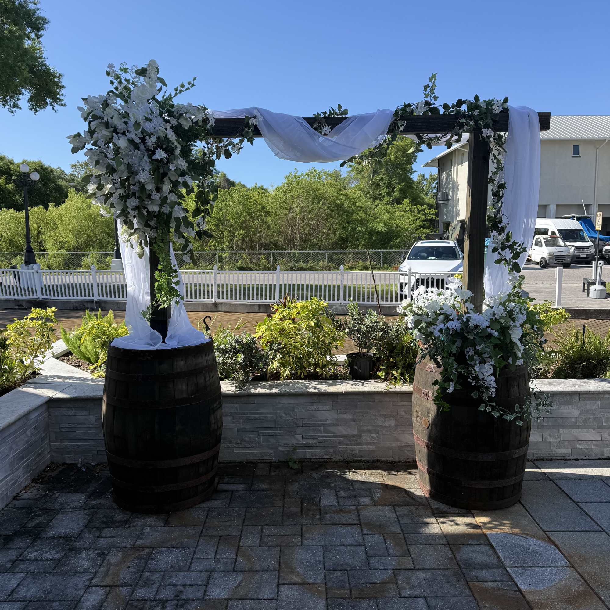 Wooden barrel arbor with a natural wood beam, styled with beautiful artificial