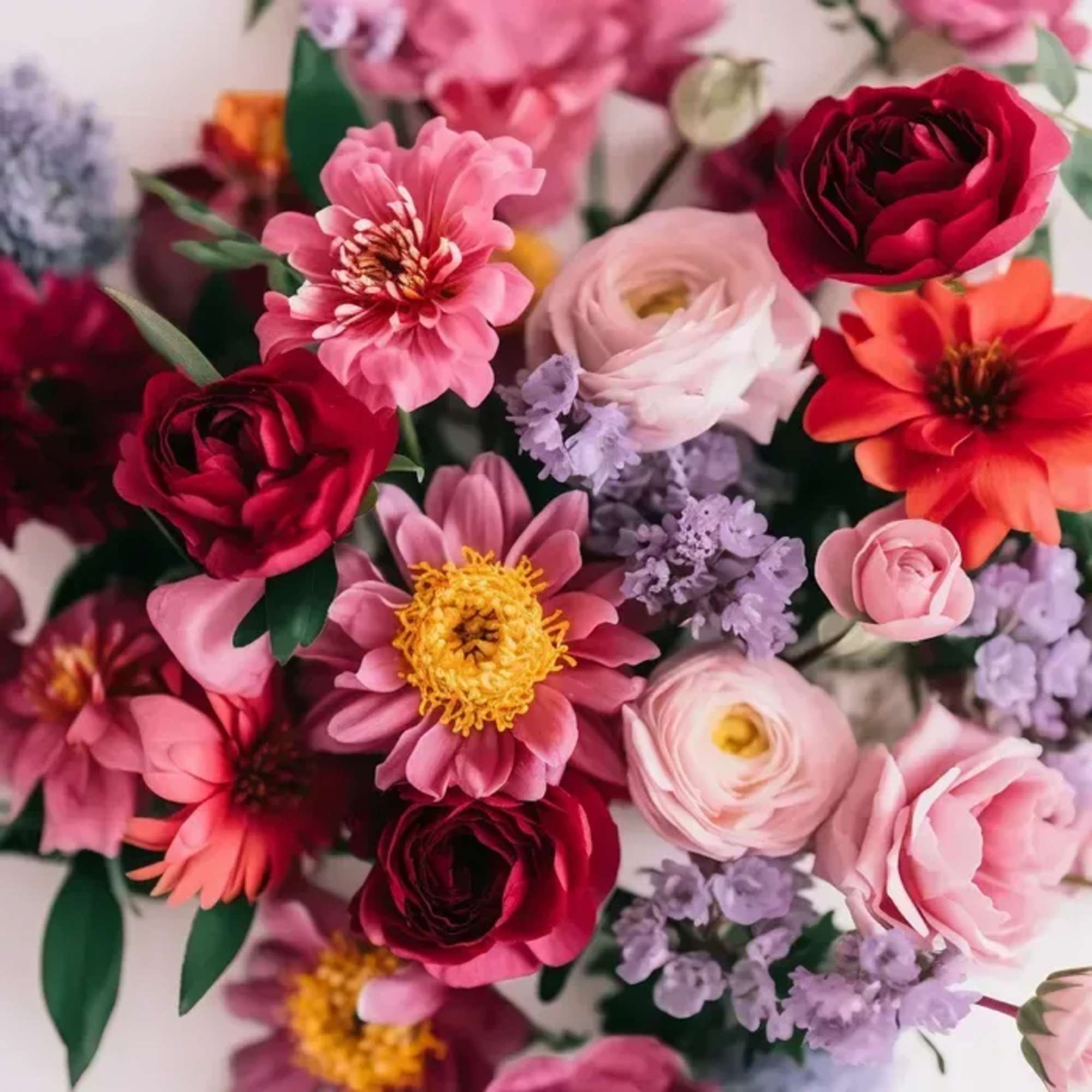 An arrangement of seasonal blooms in Berry &amp; Bright, shades of coral