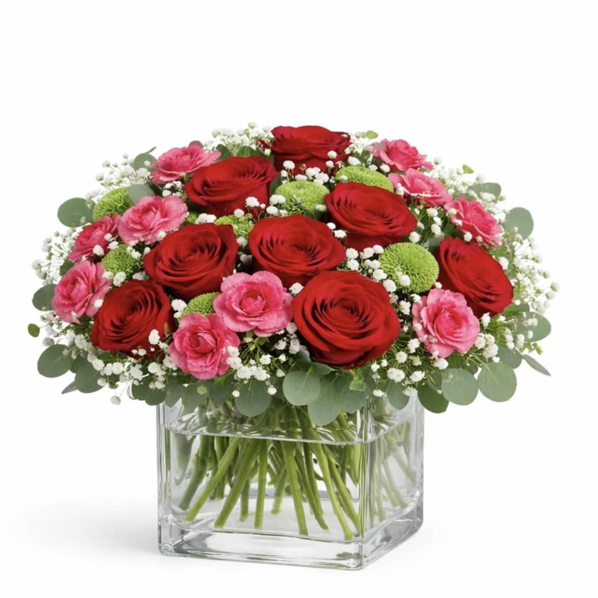 Red and pink flowers arranged in a clear square vase