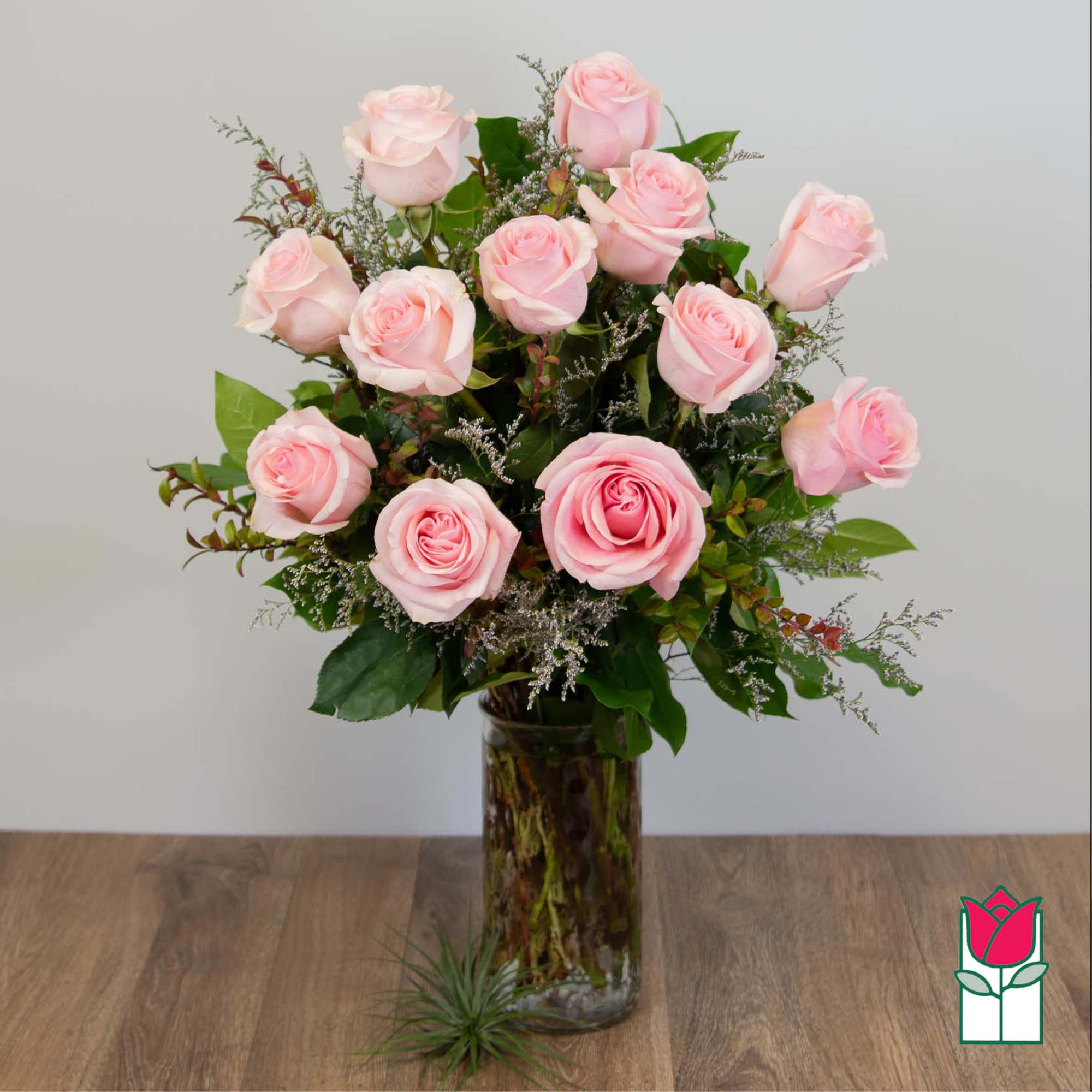 Pink roses arranged in a tall glass vase