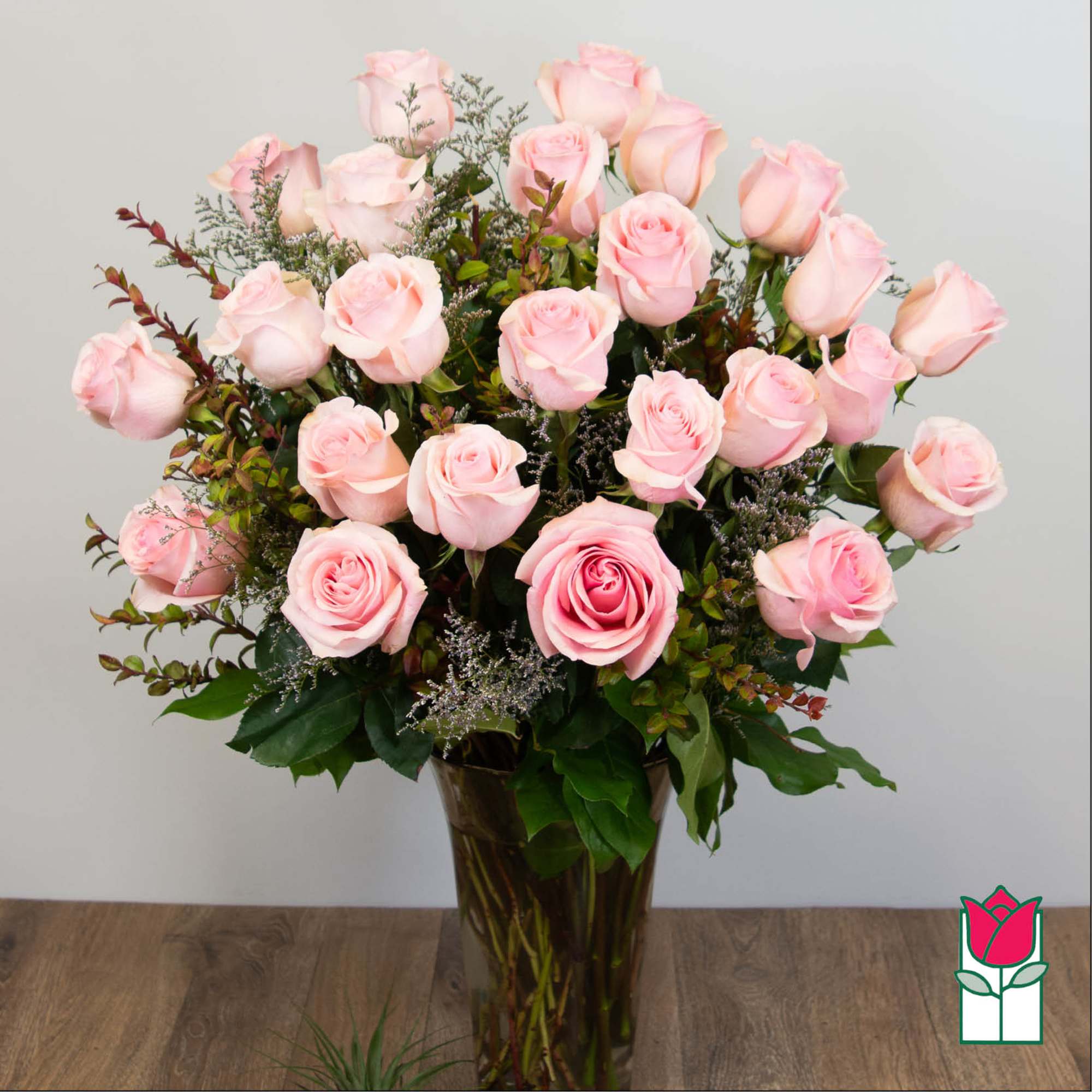 Pink roses arranged in a tall glass vase