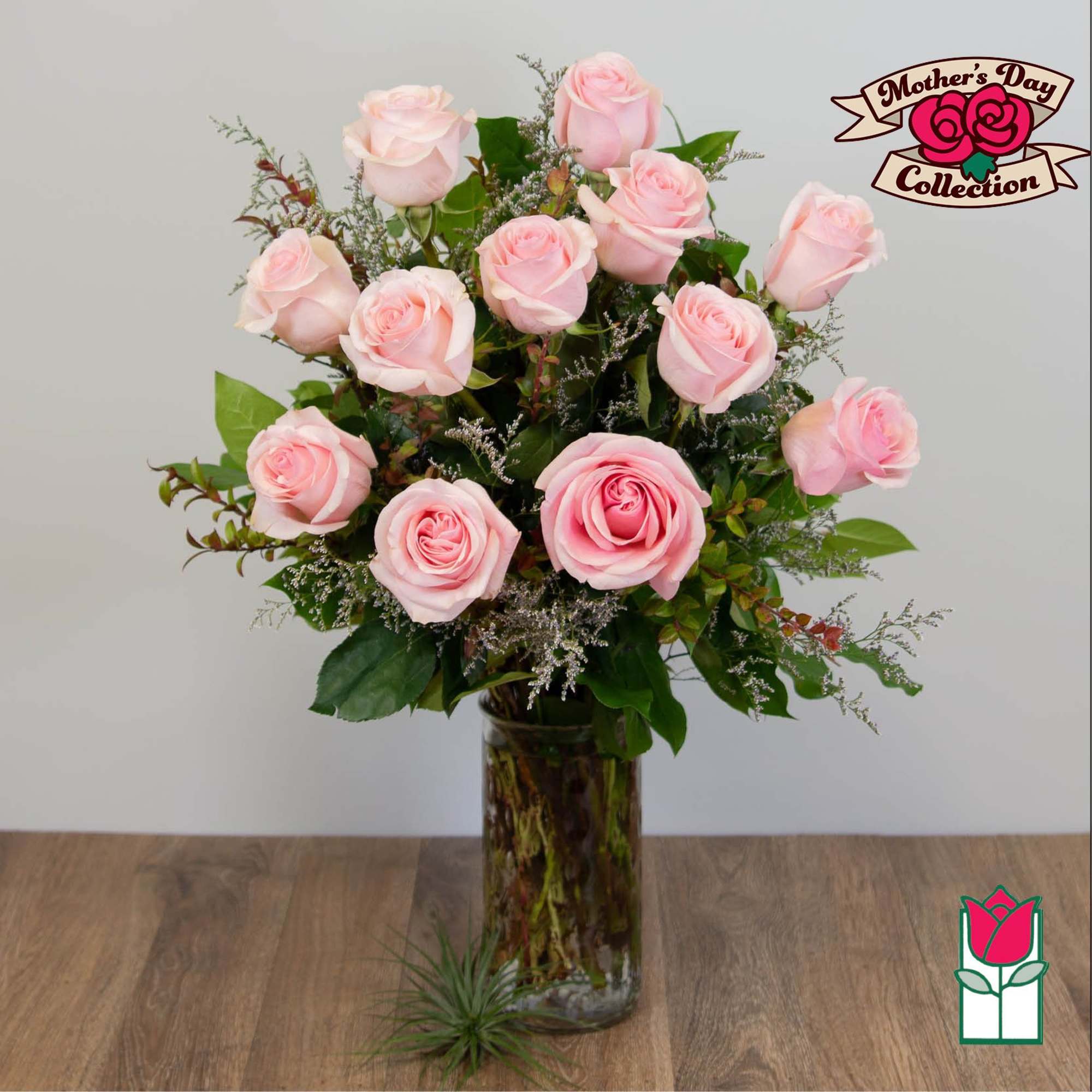 Pink roses arranged in a tall glass vase