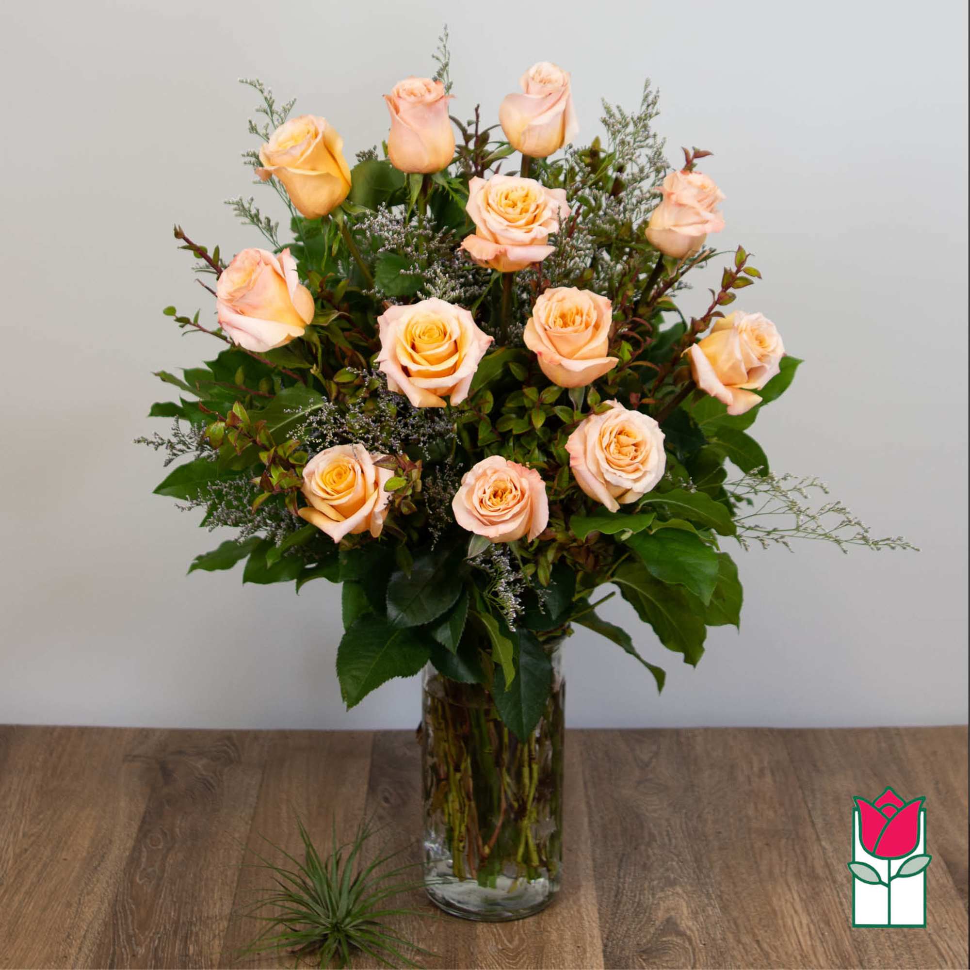 Peach roses arranged in a clear glass vase