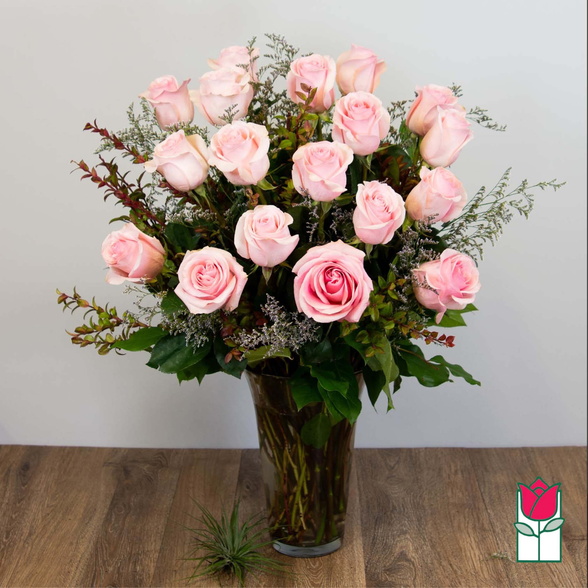 Pink roses arranged in a tall glass vase