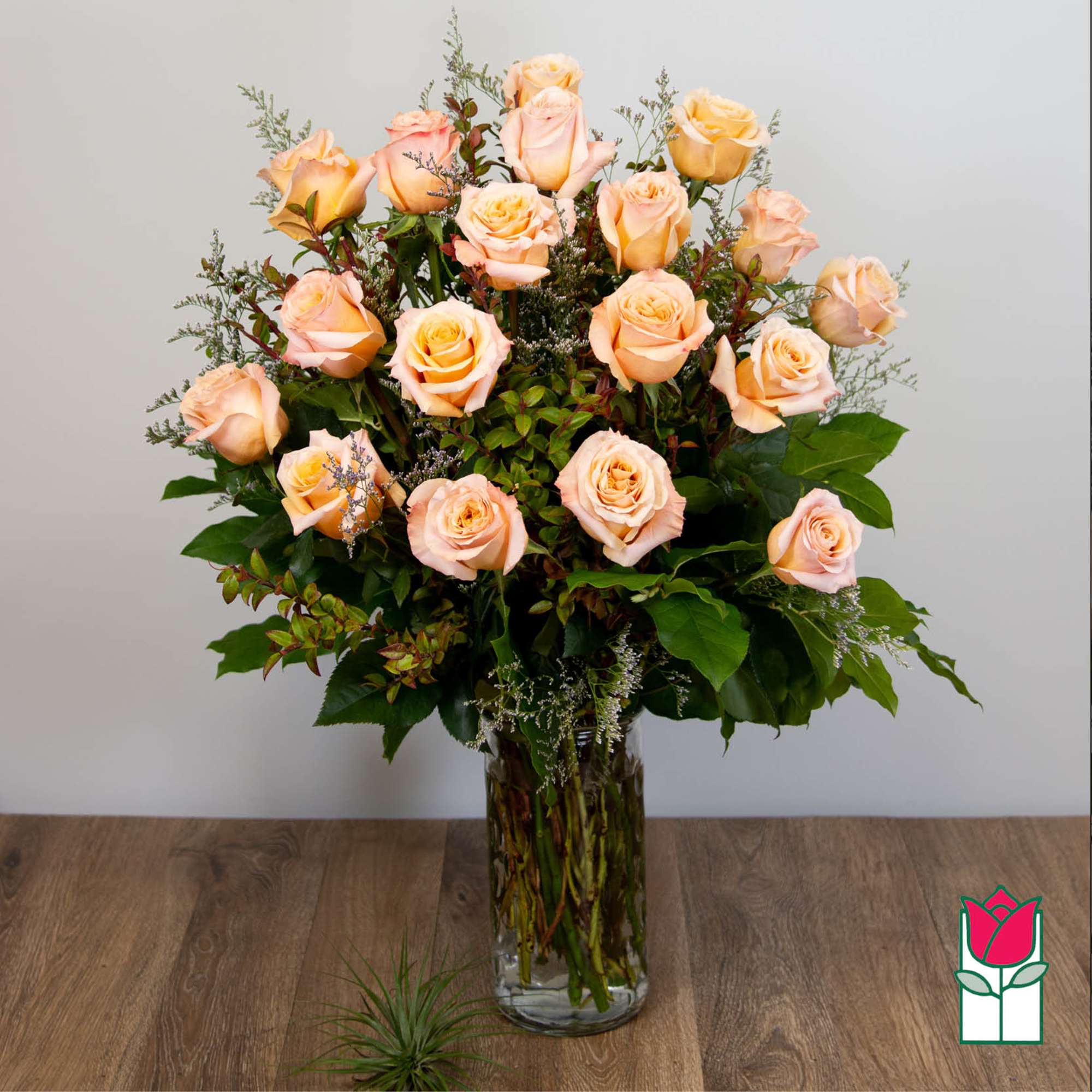 Peach roses arranged in a clear glass vase