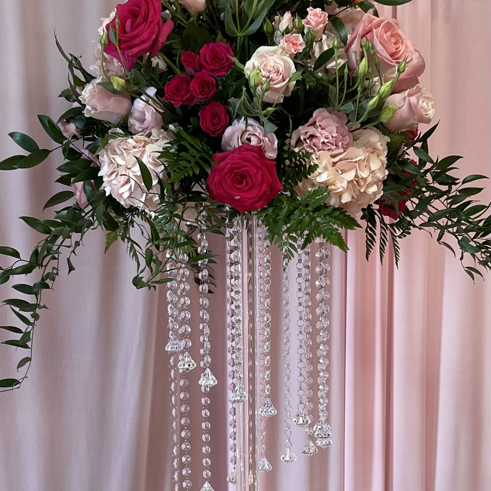 Two piece floral sitting in tall glass/acrylic vase 