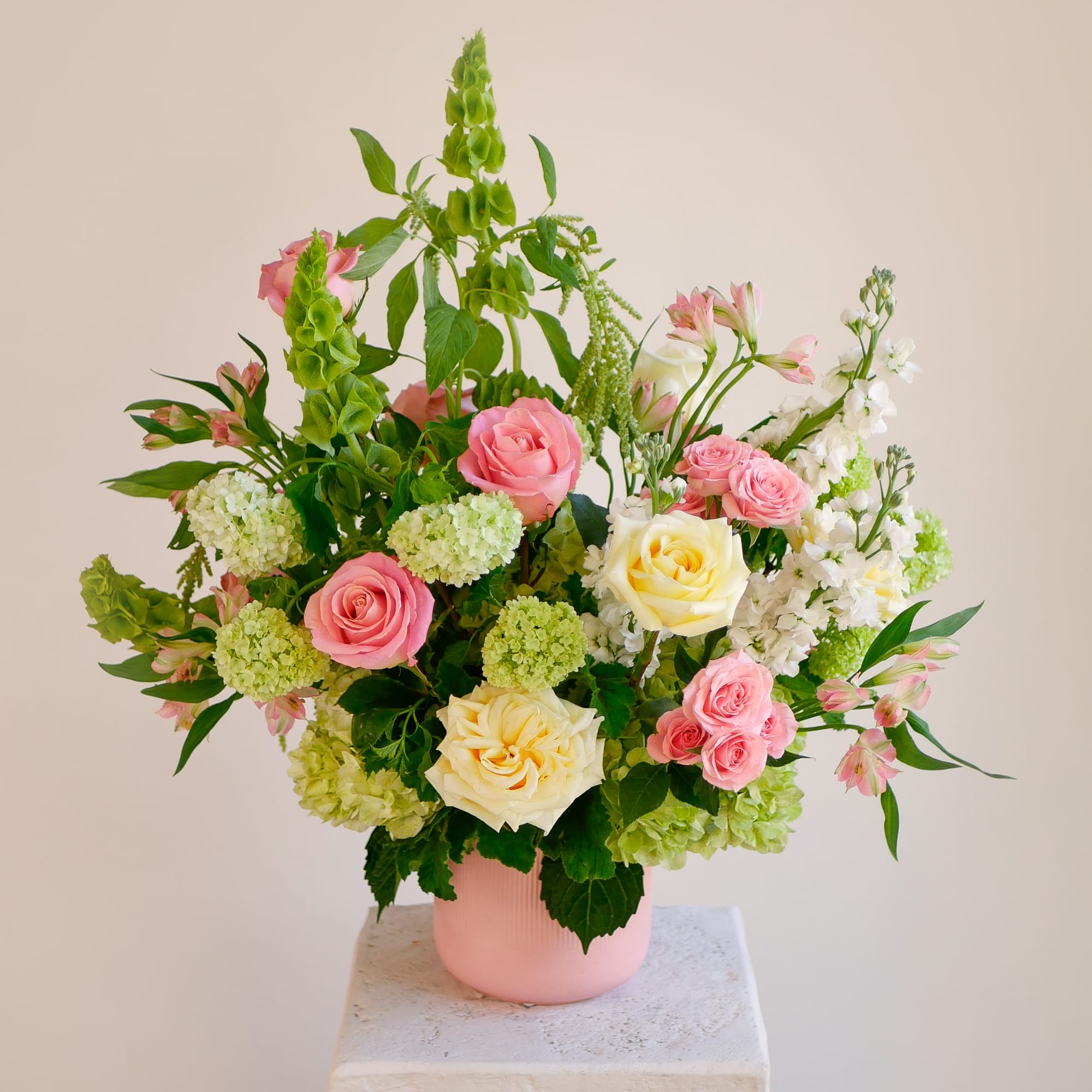 Pink and cream garden roses are the focal point of this garden-style