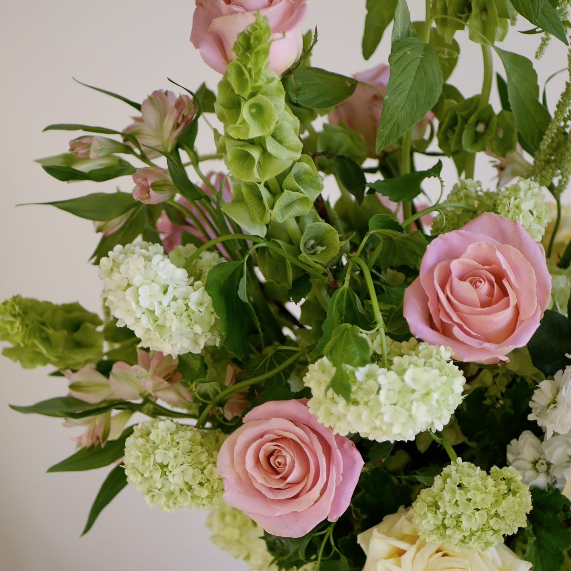 Pink and cream garden roses are the focal point of this garden-style
