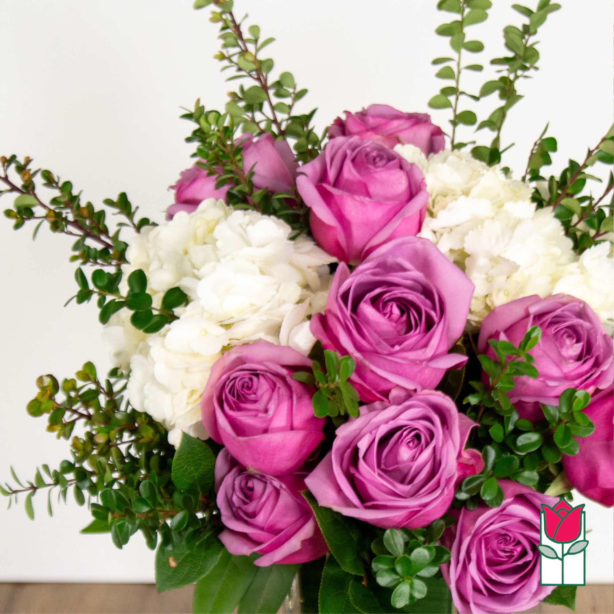 Bouquet of pink and purple roses with white hydrangeas and greenery