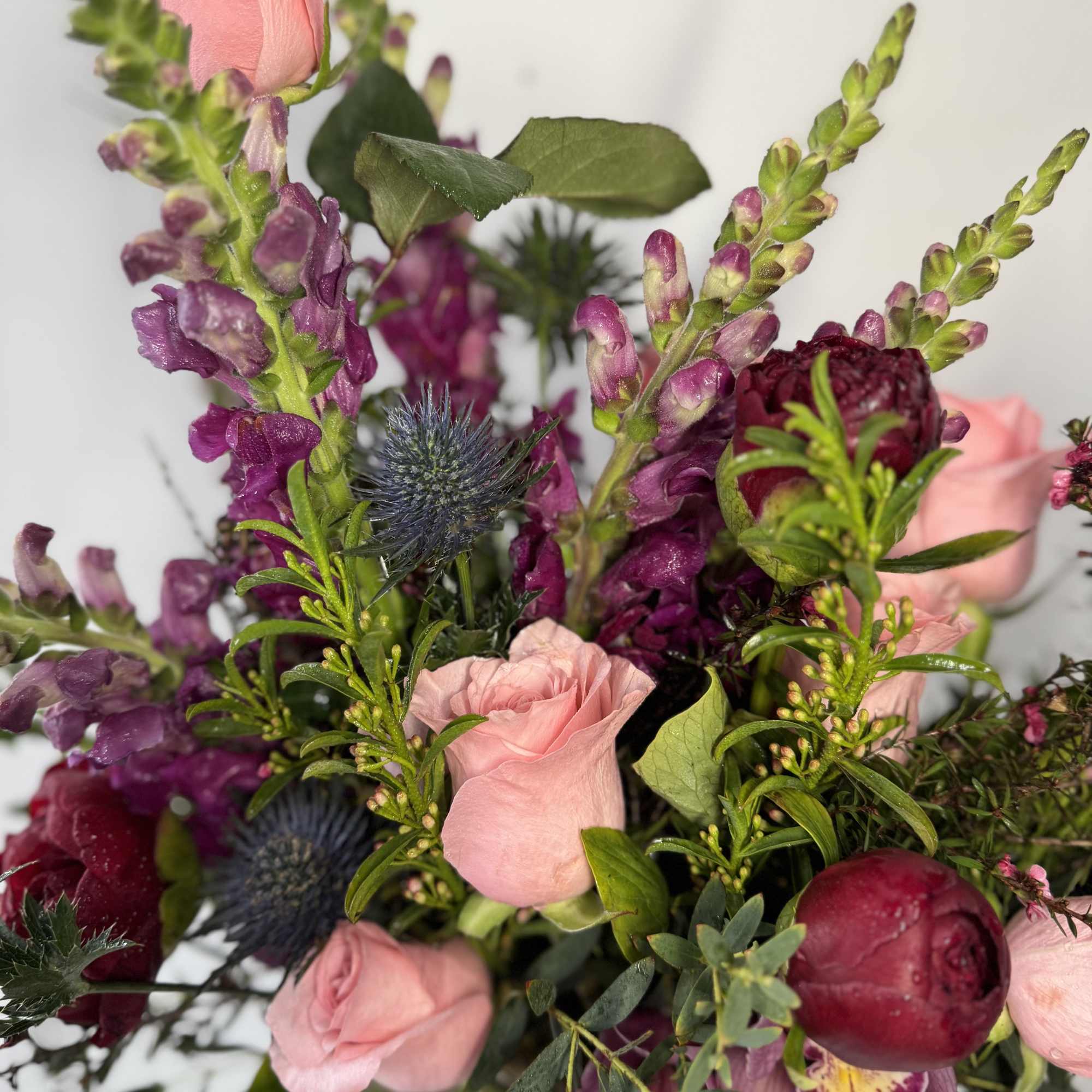 Pink roses and purple flowers in a mixed bouquet
