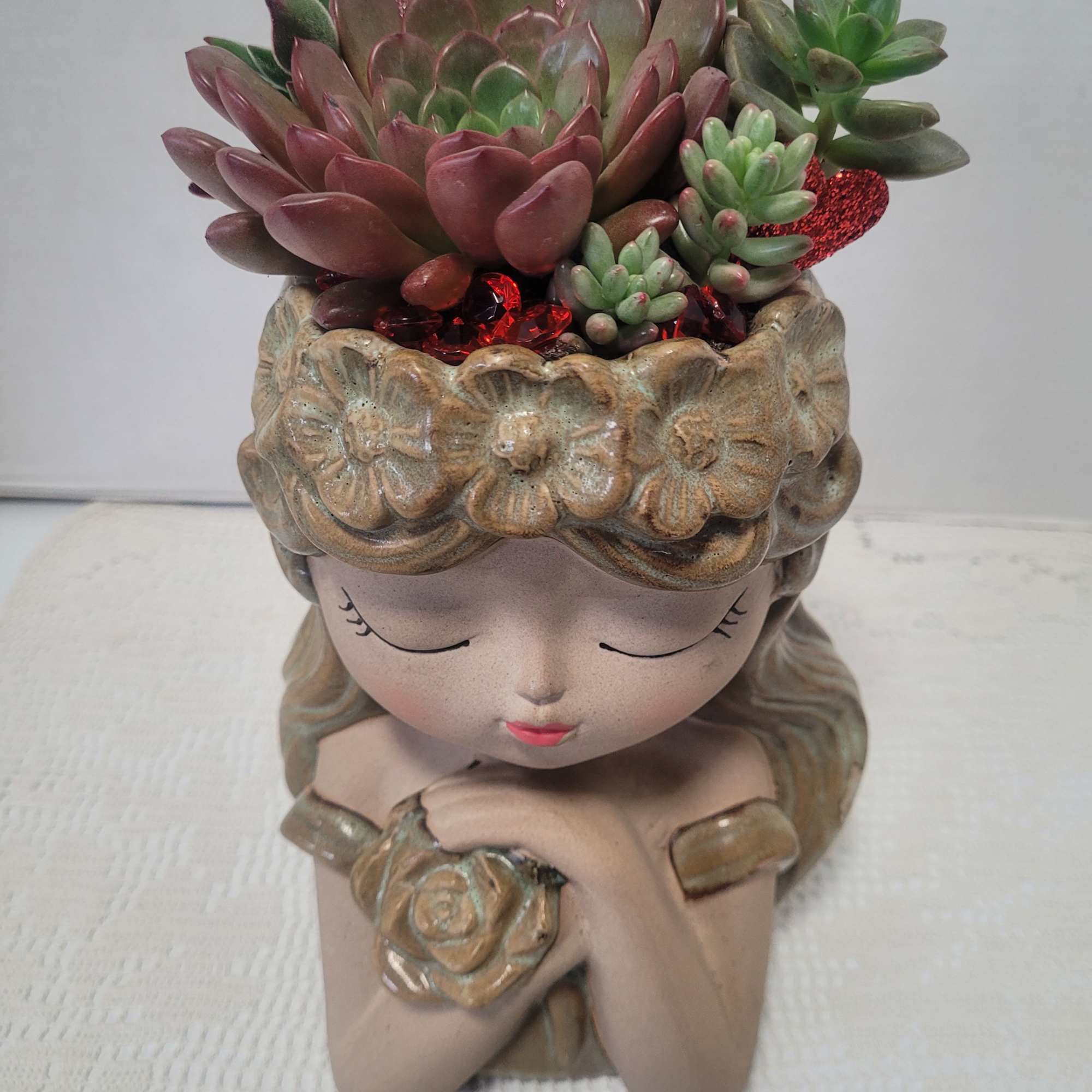 Succulent arrangement in a decorative girl-shaped planter