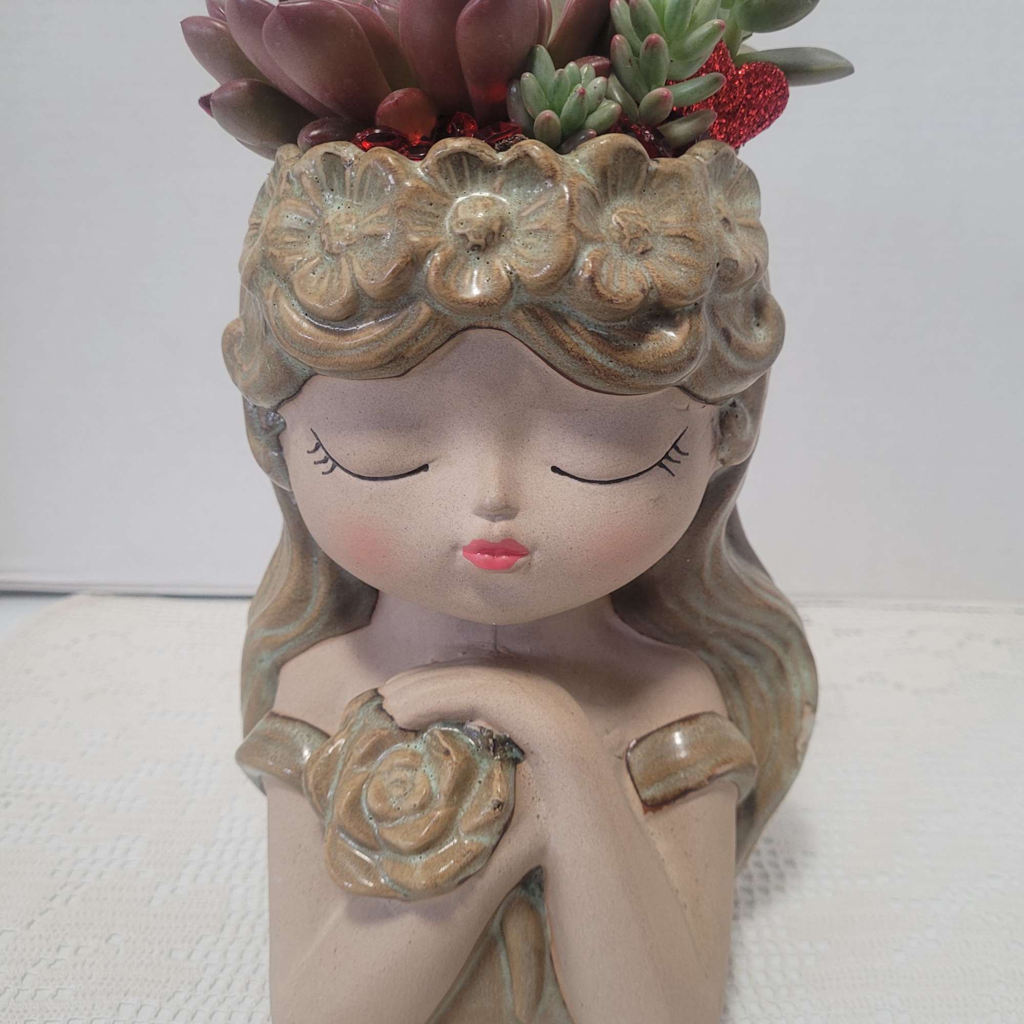 Ceramic girl planter with succulent arrangement on top