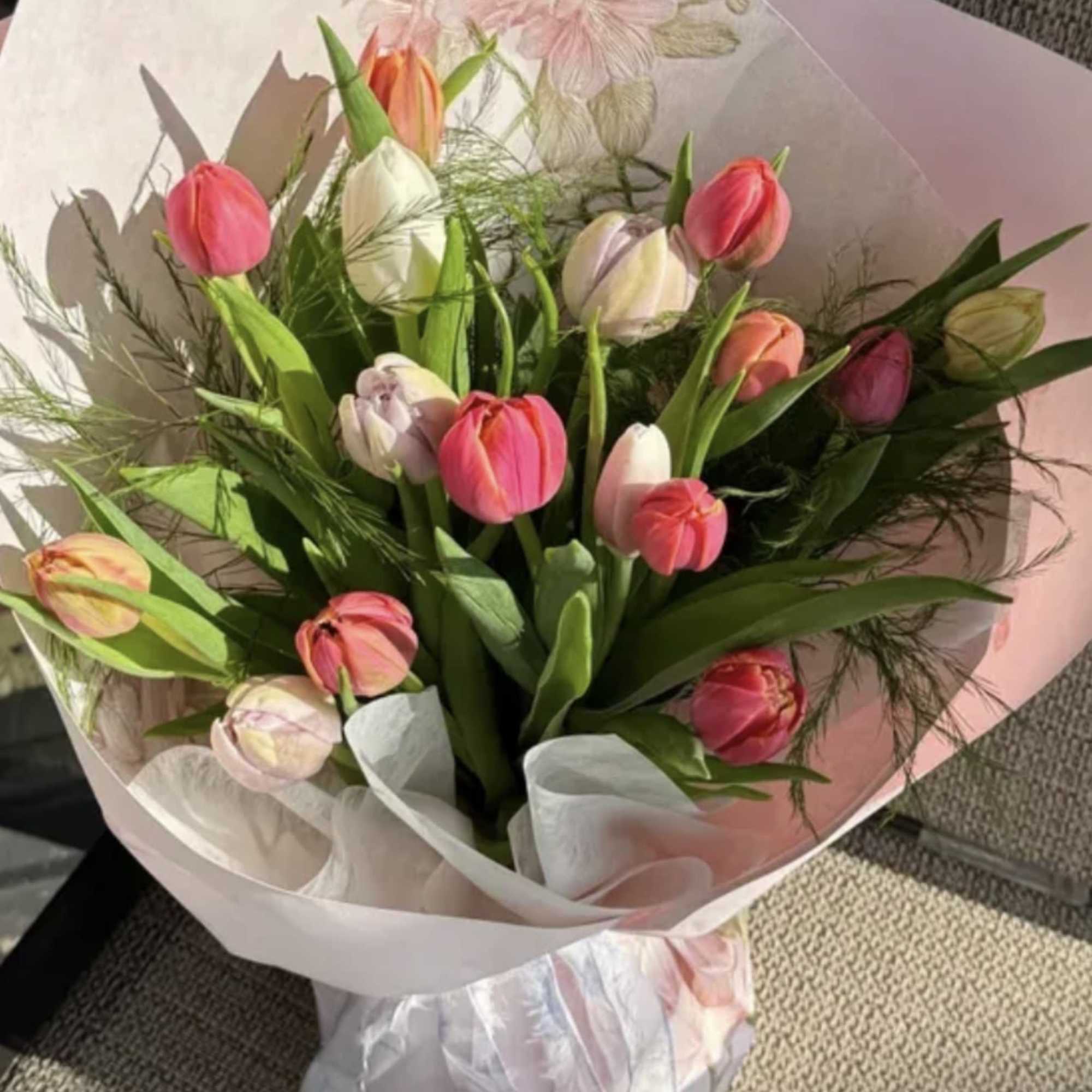 The Happy Wrap is a cheerful bouquet of fresh vibrant tulips, beautifully