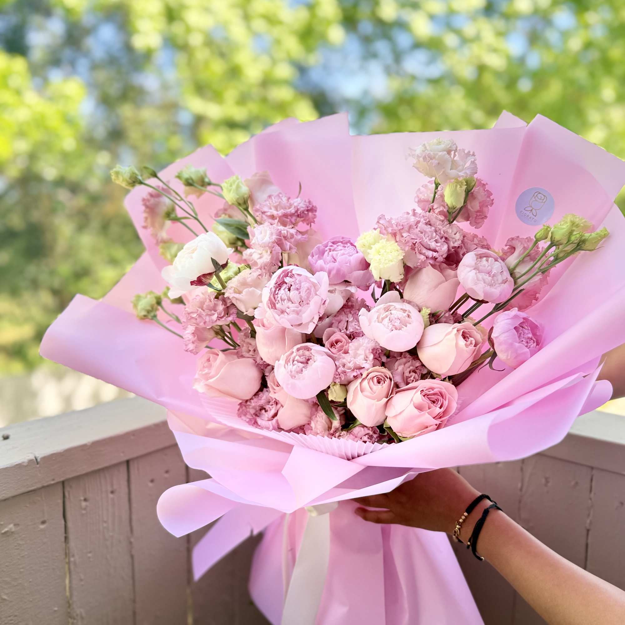 Soft blush peonies and rounded pink roses take center stage in this