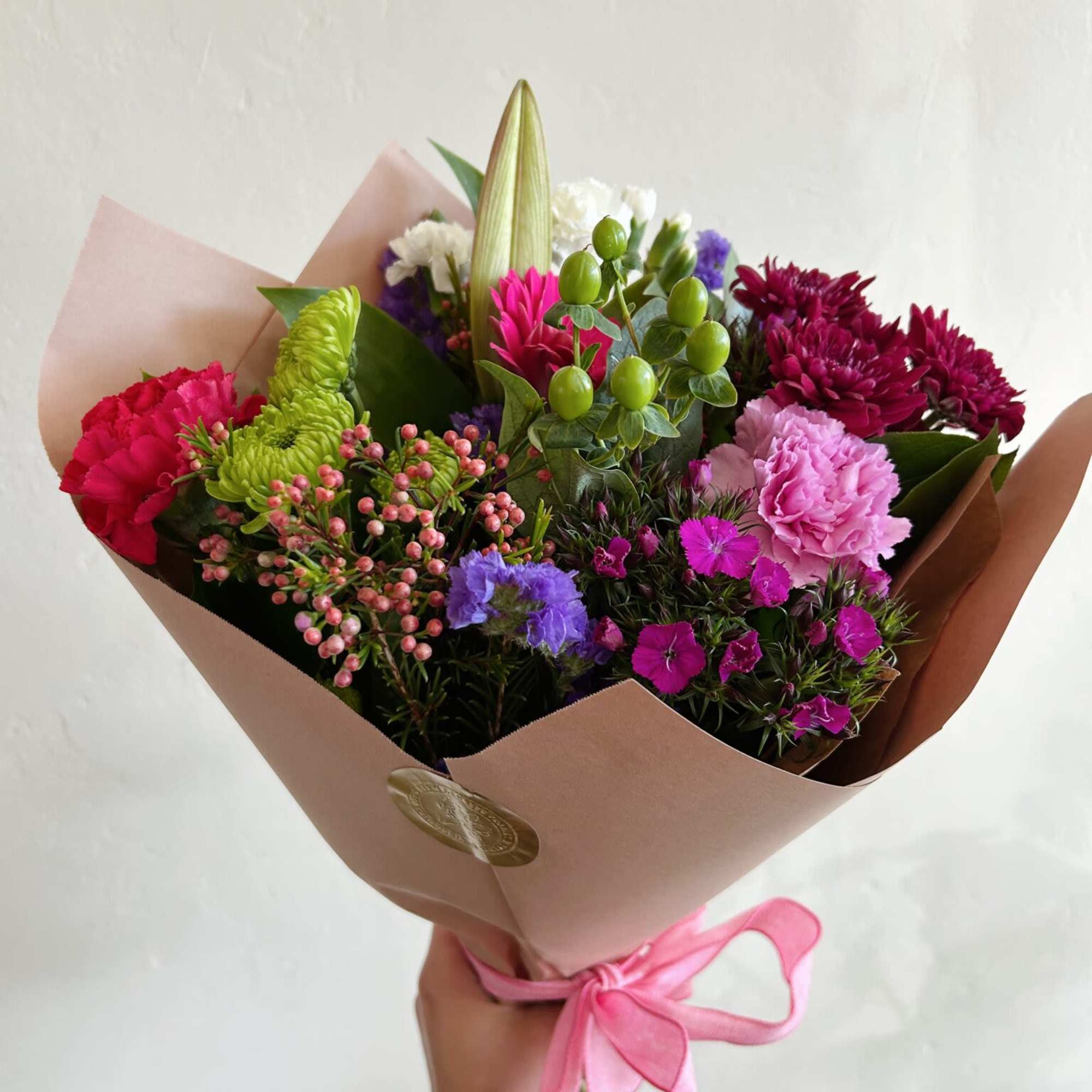 Bright, garden-style color takes center stage in this wrapped seasonal bouquet -