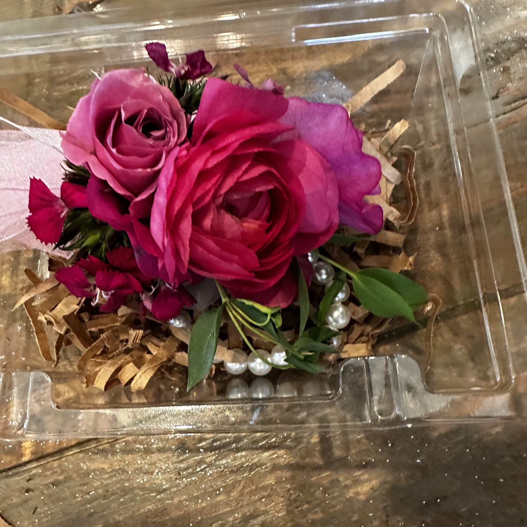 Pink rose corsage in a clear plastic box