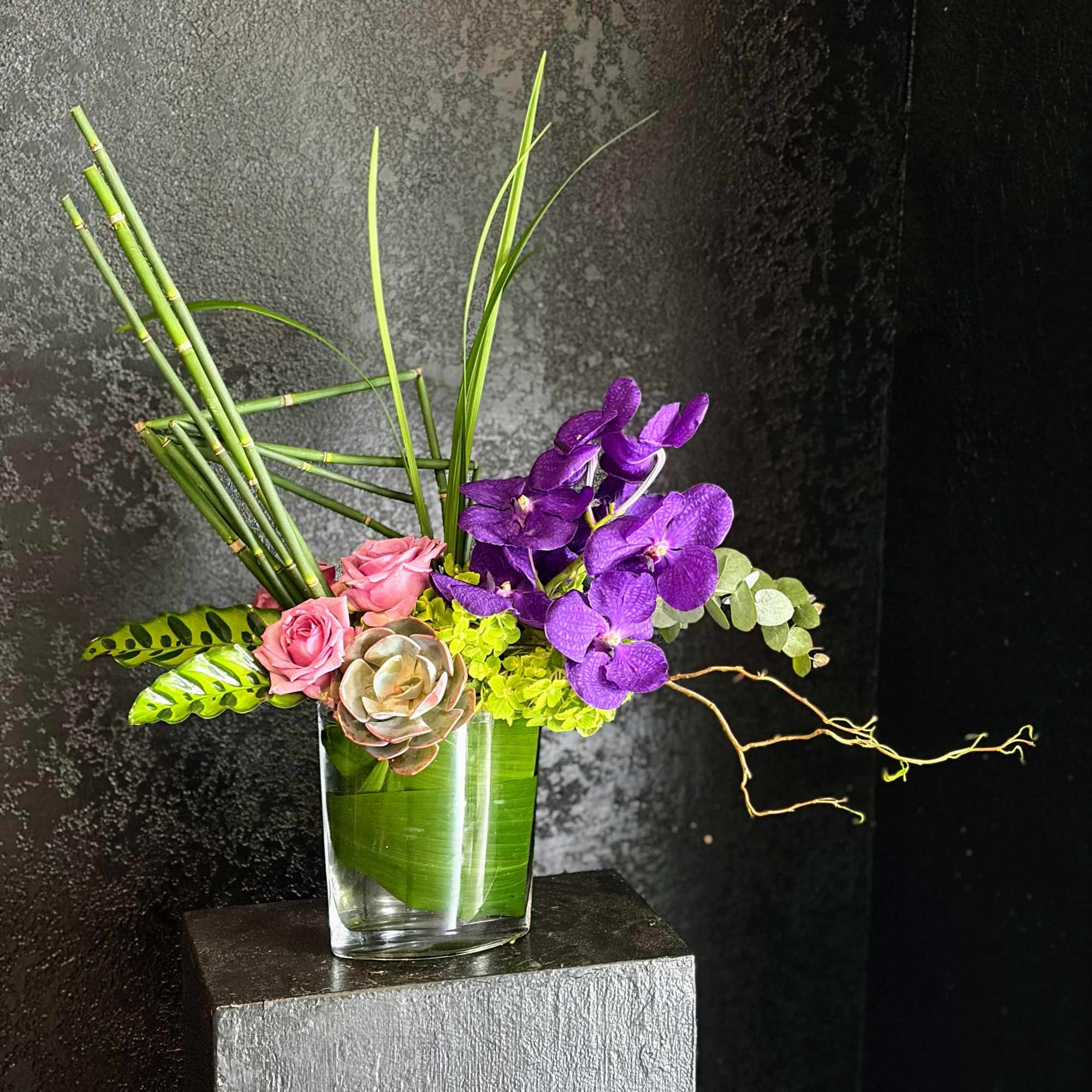Vanda orchids are the stand-out star of this arrangement.  Roses and