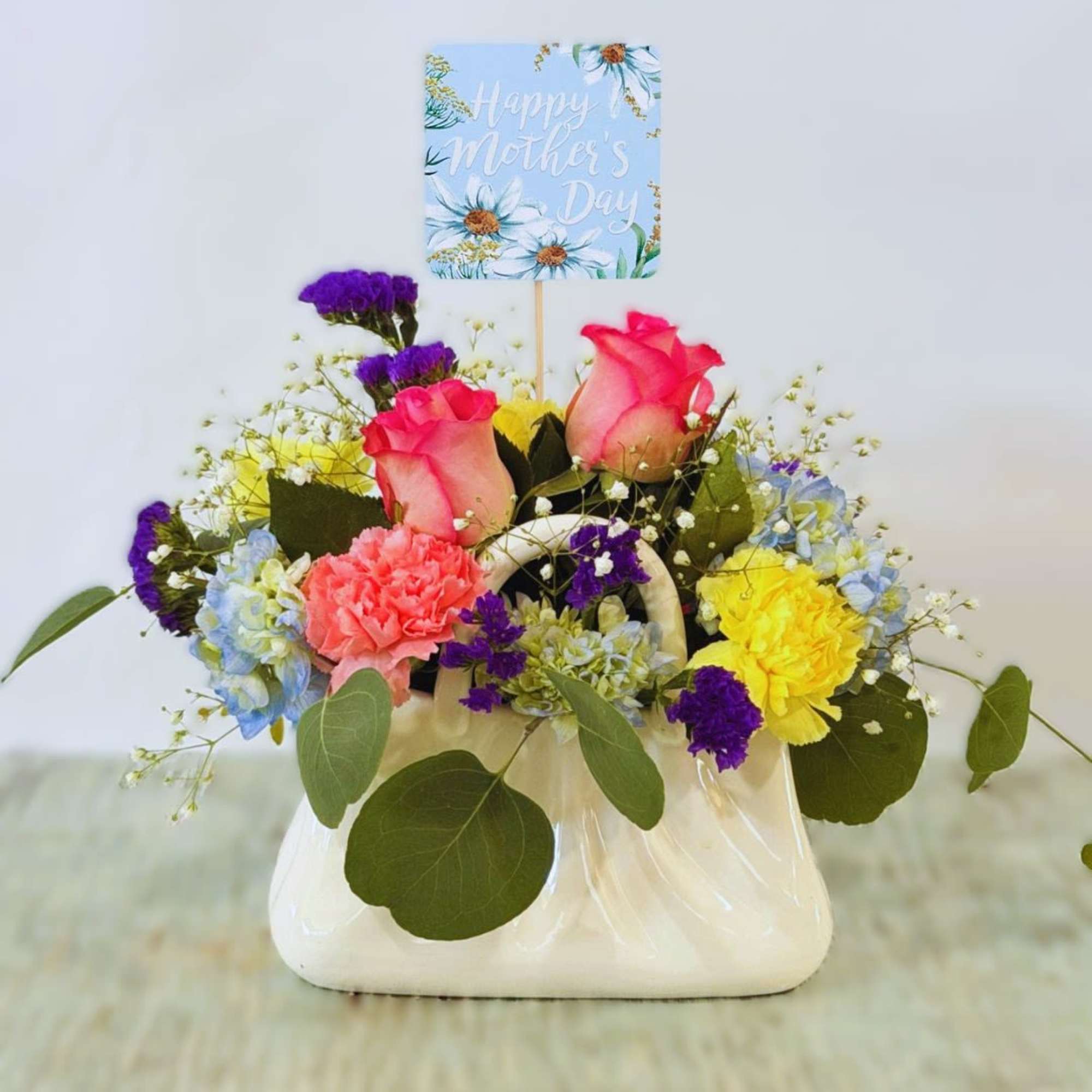 A playful cluster of pink roses and pale blue hydrangeas arranged in