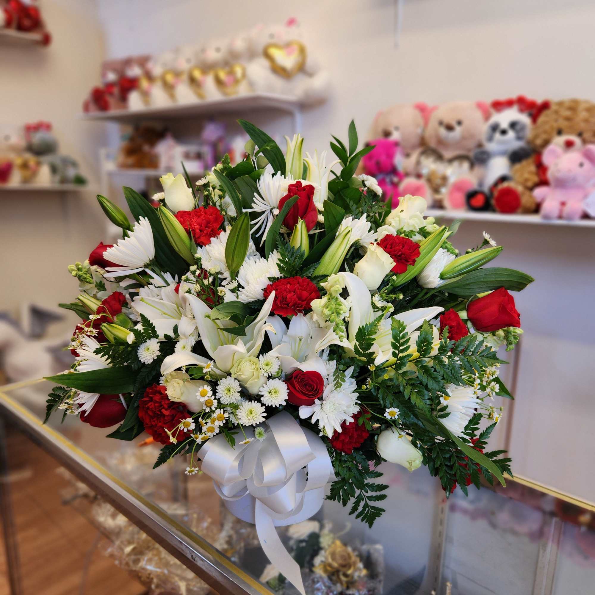Large bouquet of red and white flowers tied with a white ribbon