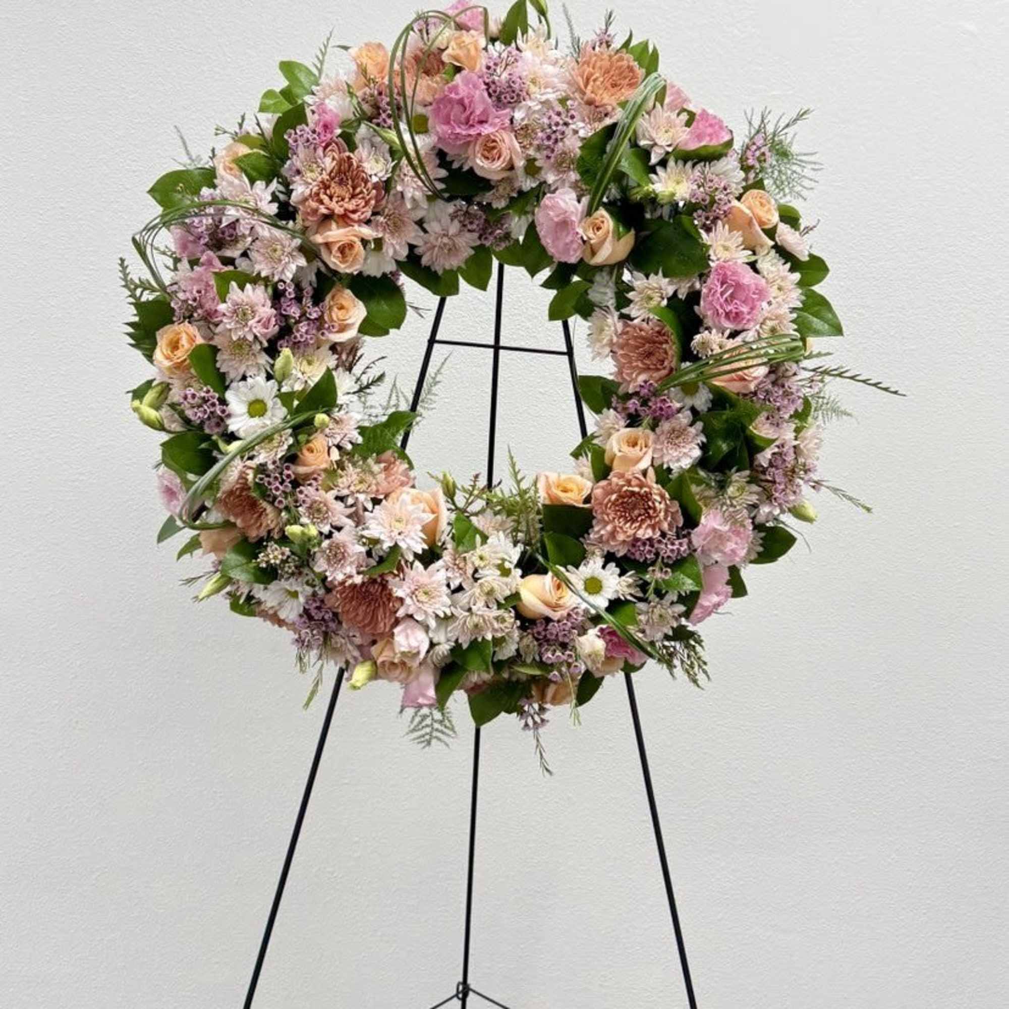 A beautiful white and green tribute wreath that calms, this easel arrangement
