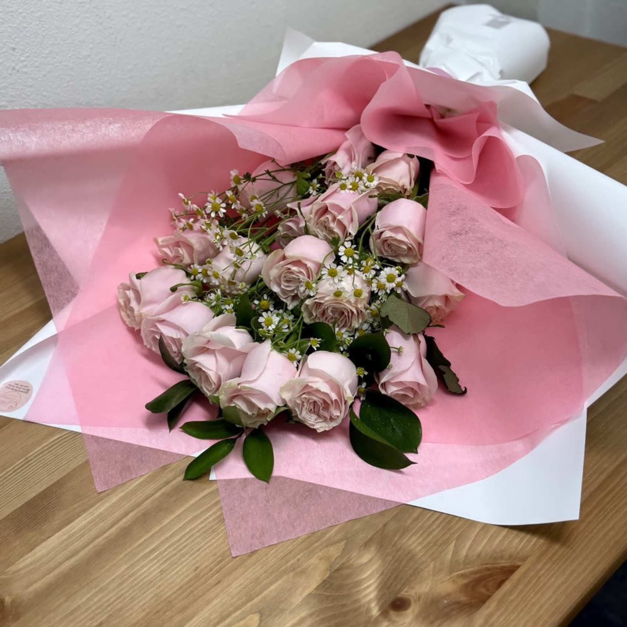 Pink rose bouquet wrapped in pink and white paper