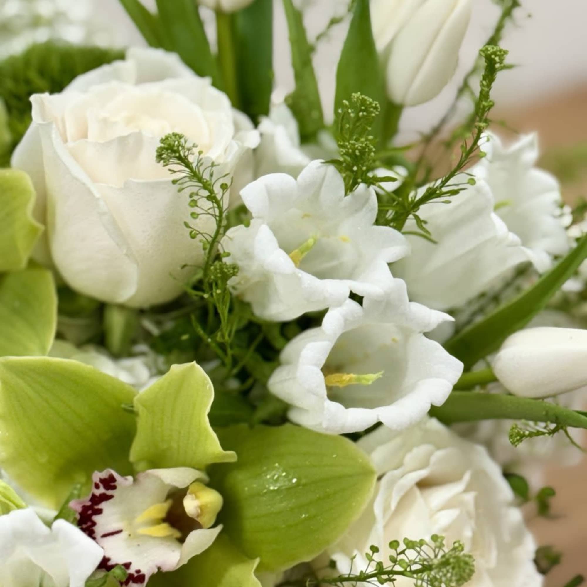 White roses and lilies with green orchids in a bouquet