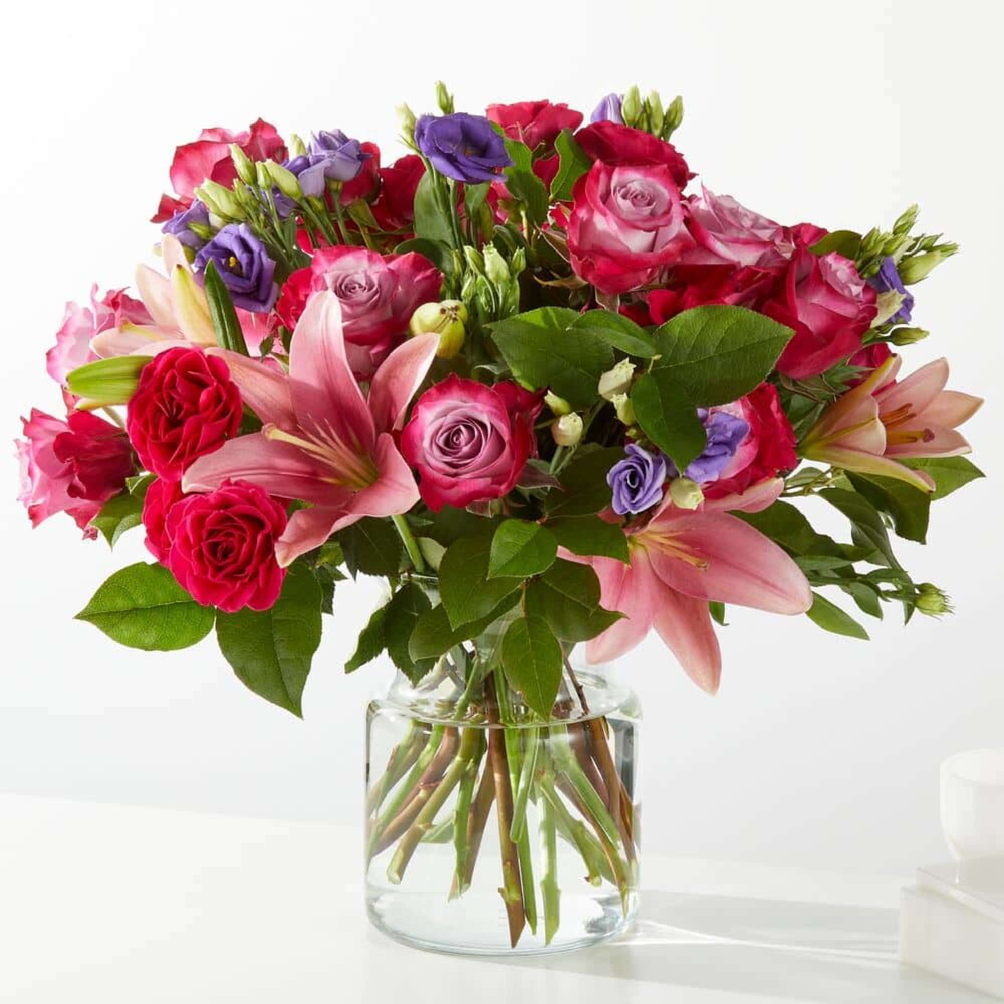 Bouquet of pink and purple flowers in a clear glass vase