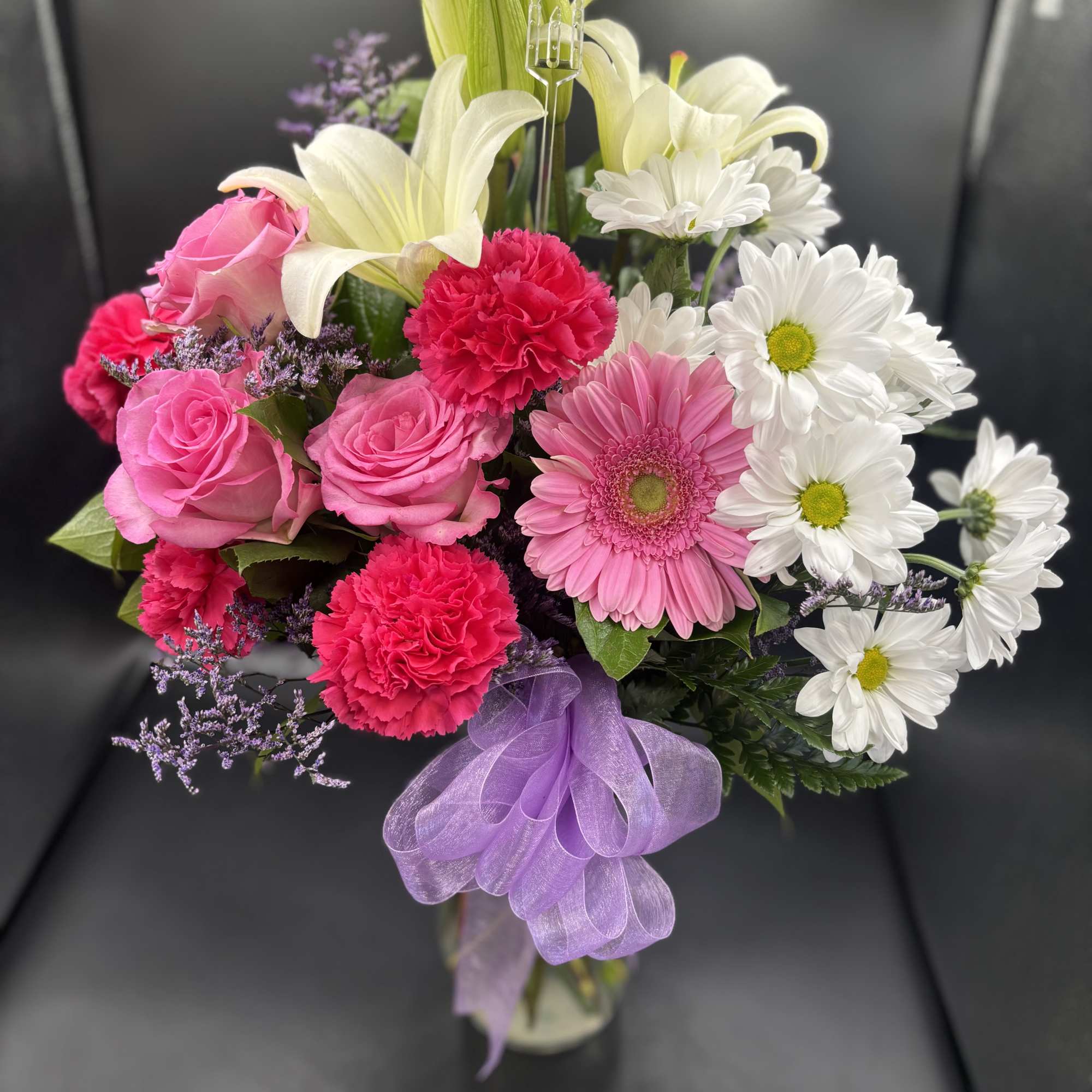 fresh roses , gerbers , carnations with greenery  

The color of