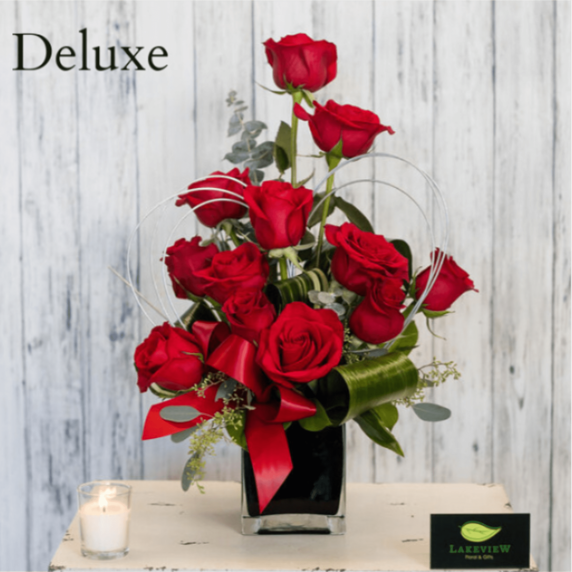 Red roses arranged in a black vase with a red ribbon