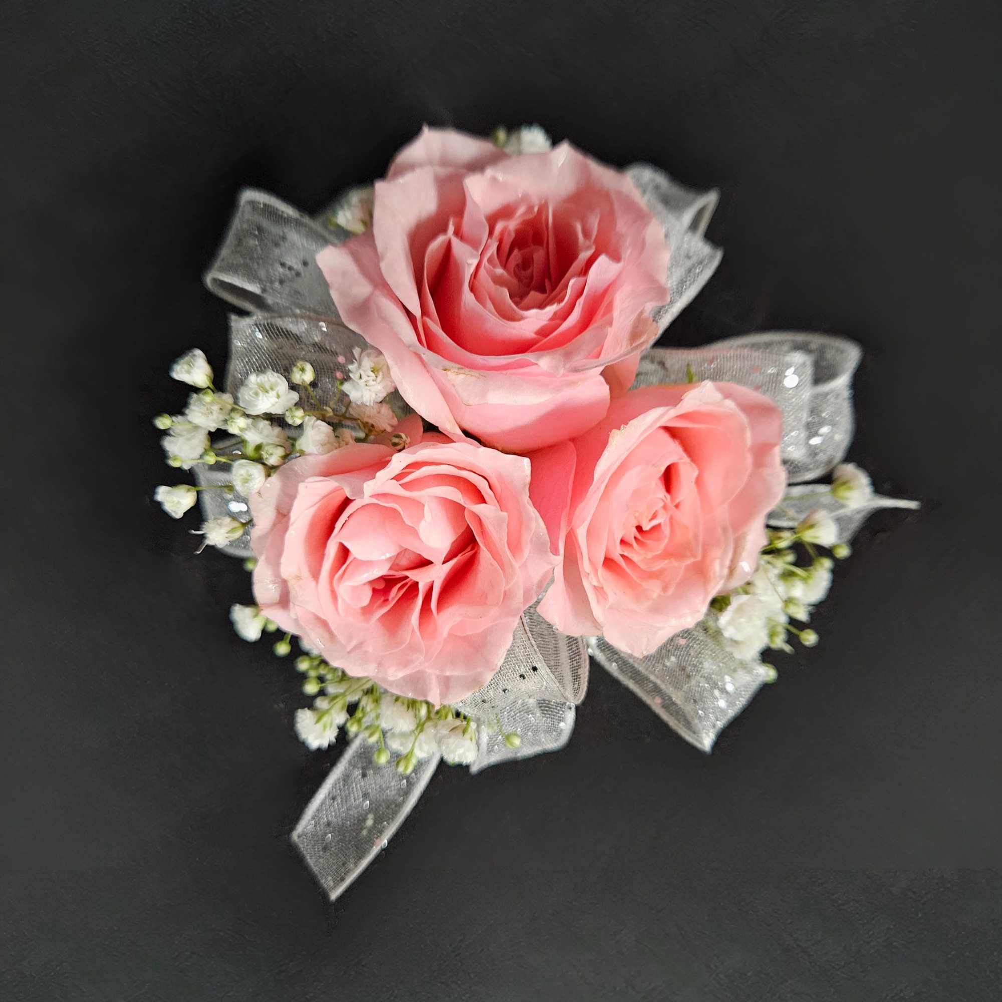 A classic spray rose corsage hand-tied in satin ribbon that compliments any