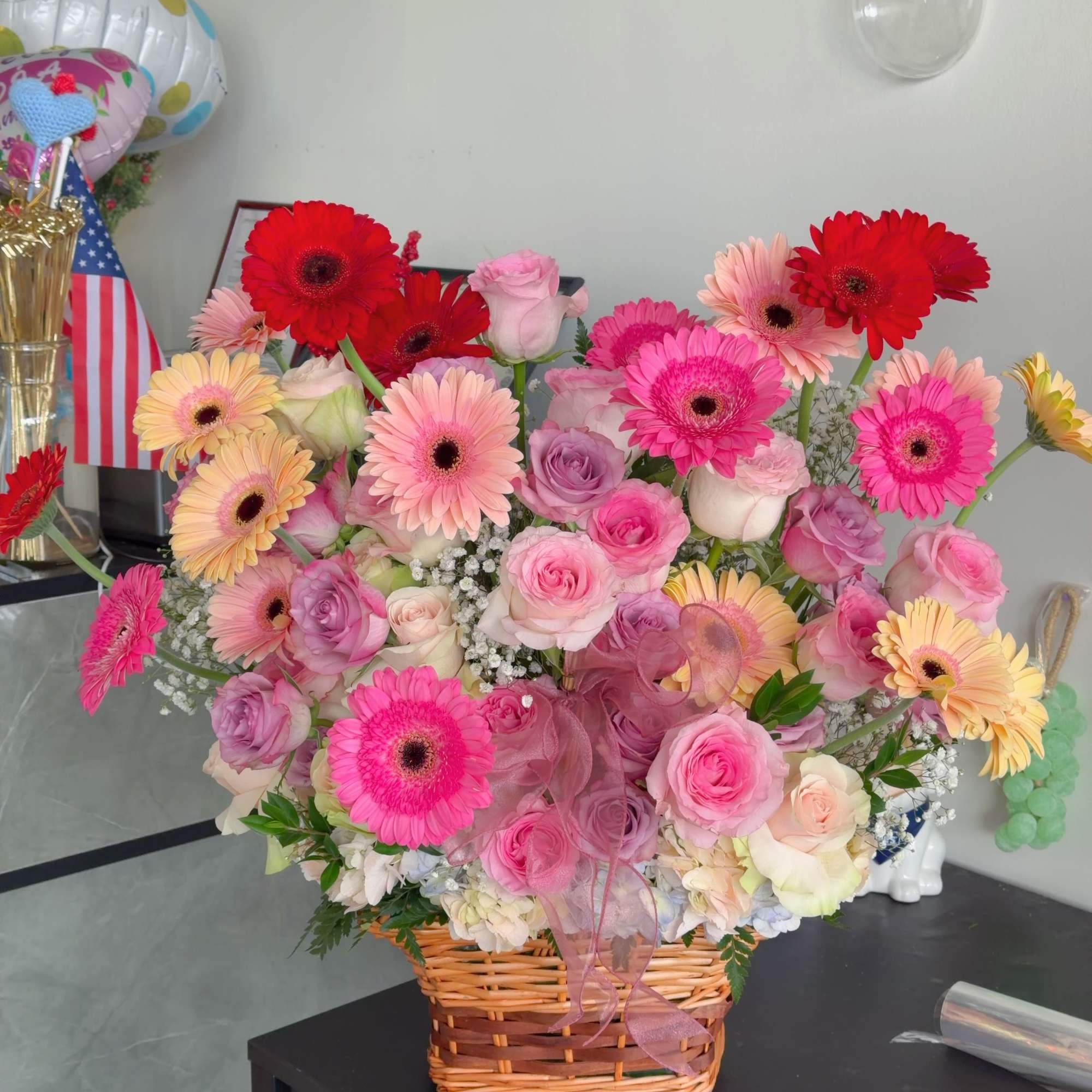 The product contains roses, gerbera daisies, green leaves stuffed, and is placed