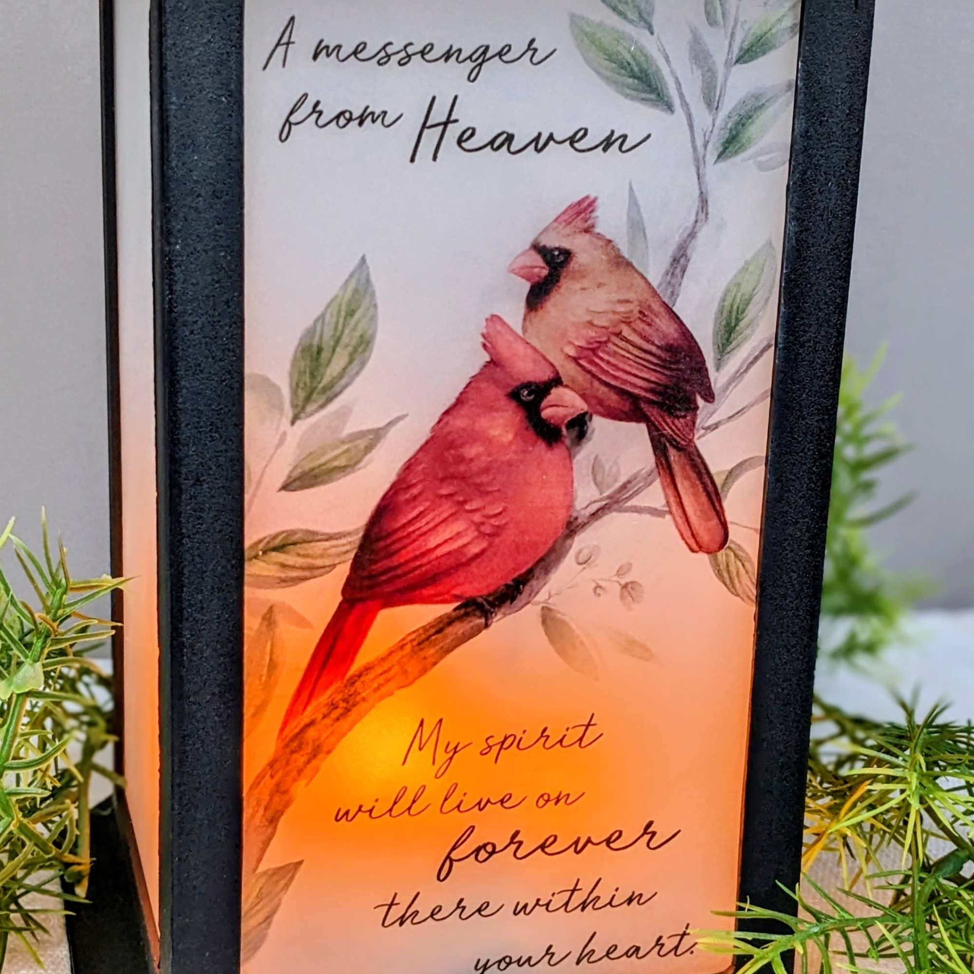 Black lantern with a memorial card showing two cardinals and text
