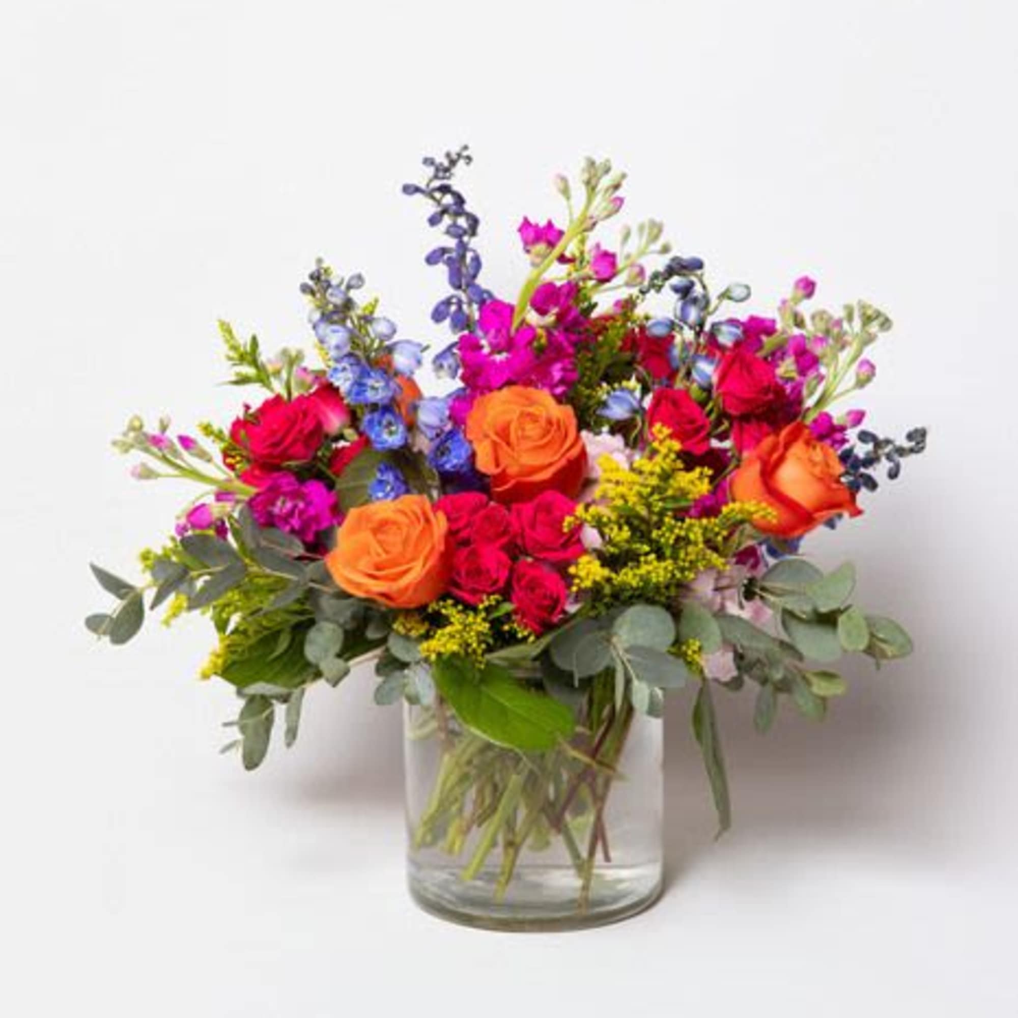 This floral arrangement is a vibrant and energetic mix of bold colors