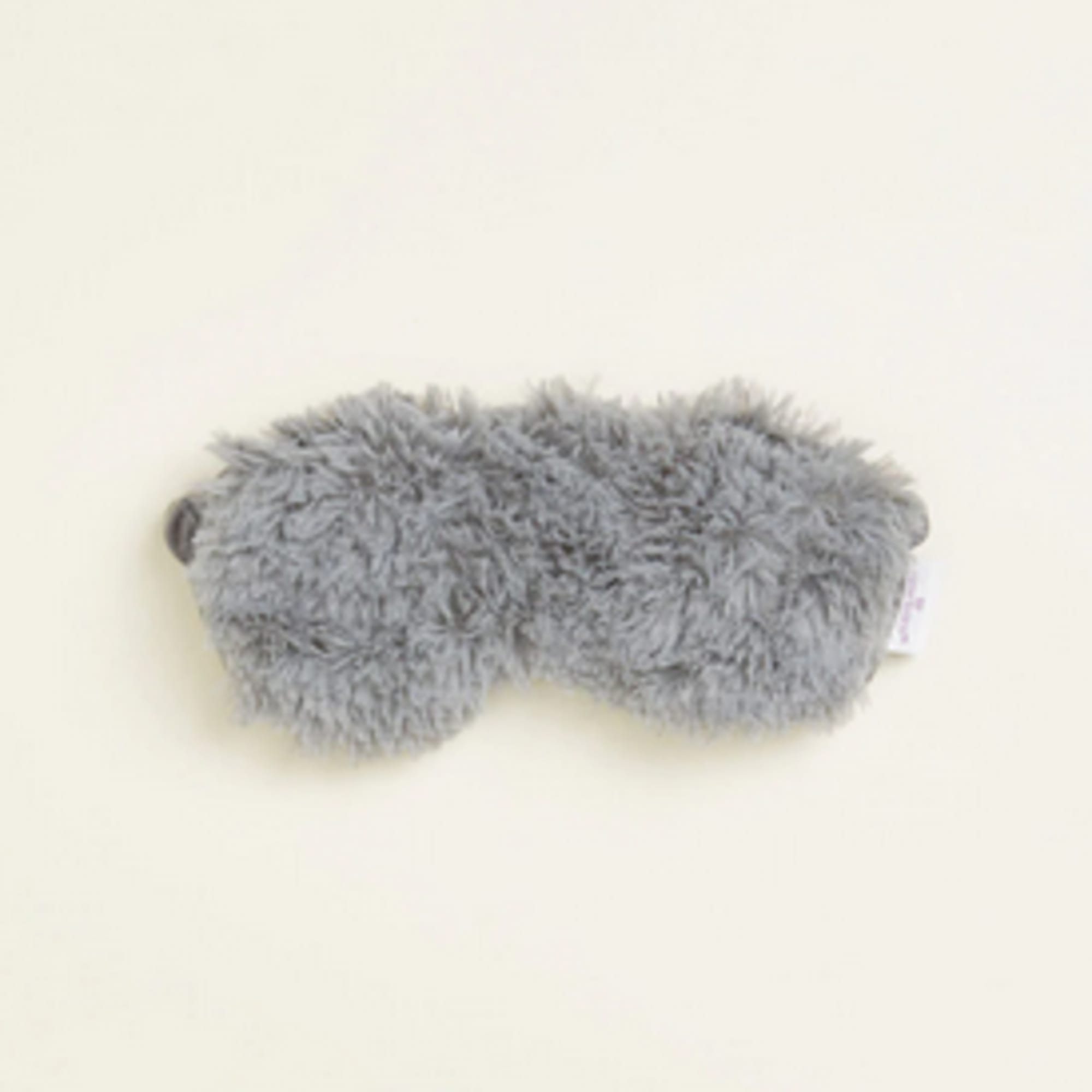 Gray fuzzy plush eye mask on a light background