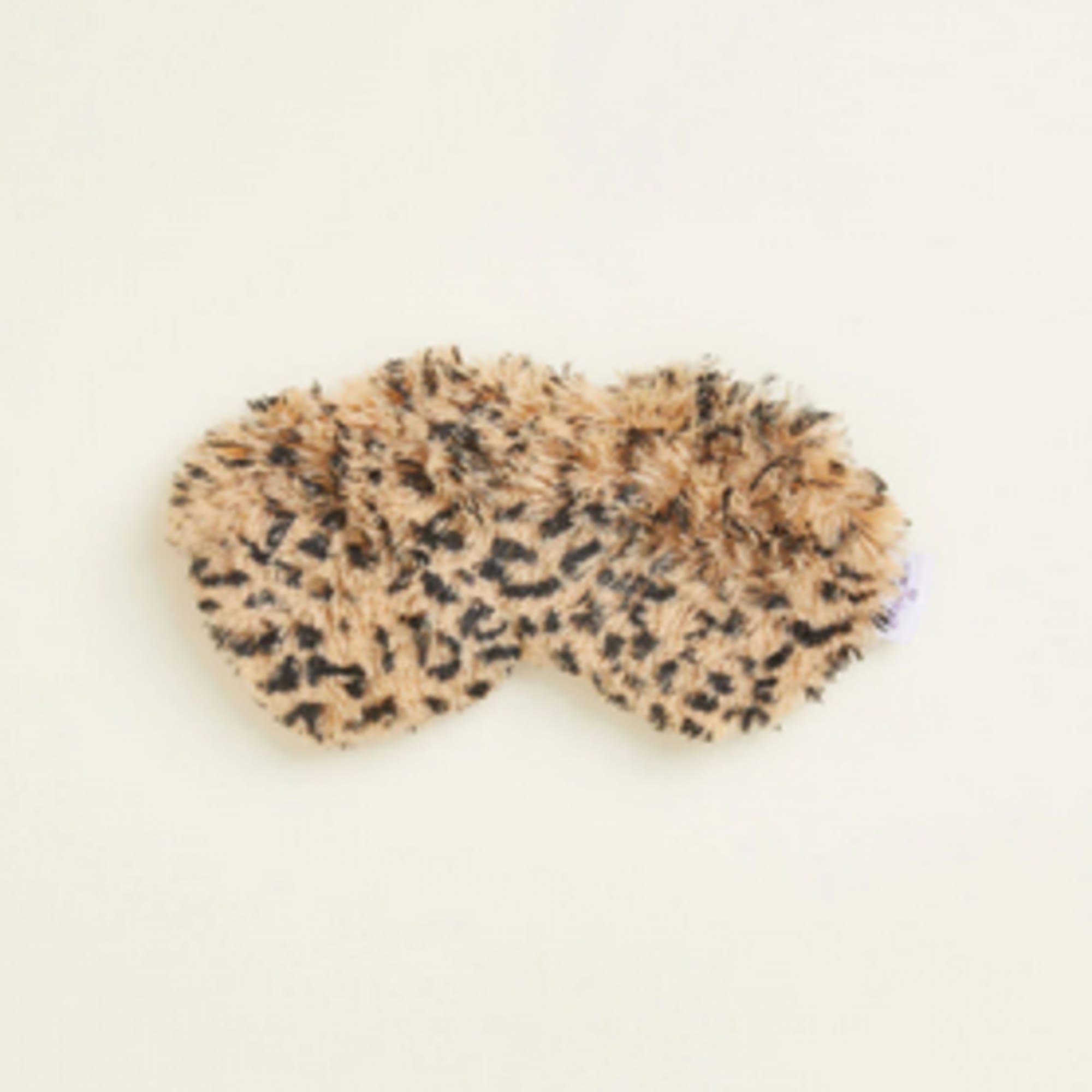 Leopard-print fuzzy sleep mask on a plain background