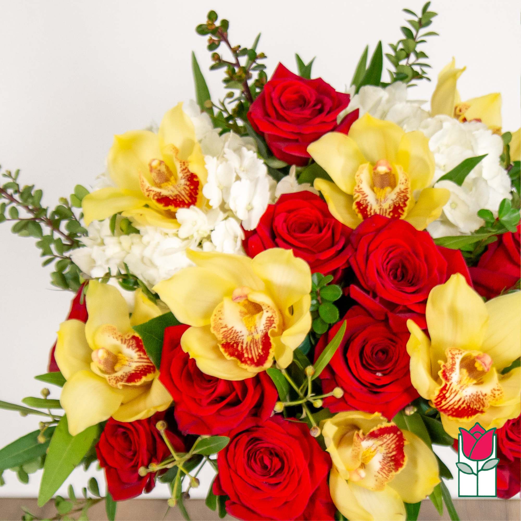 Bouquet of red roses and yellow orchids with white filler flowers
