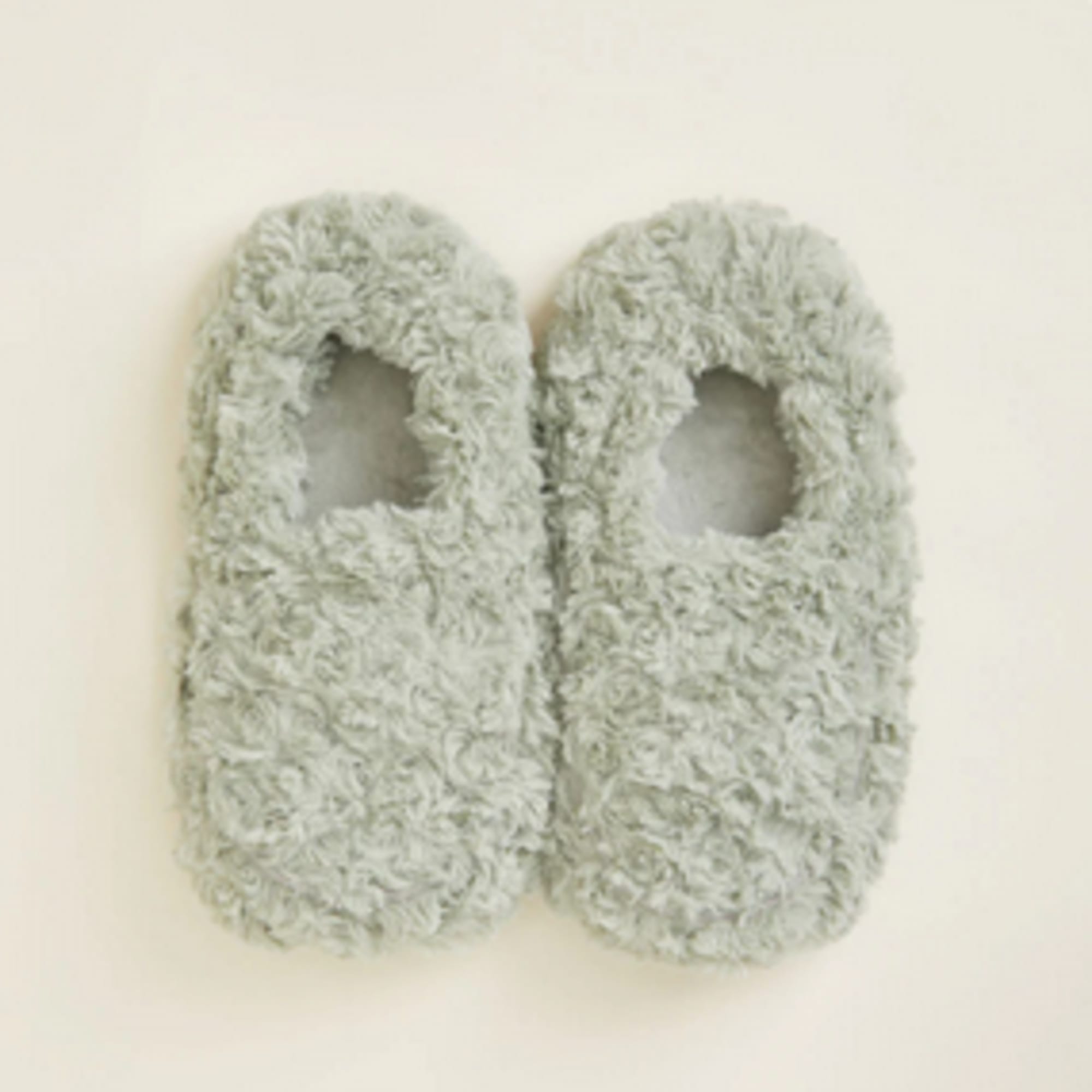 Pair of fuzzy gray slippers on a plain background