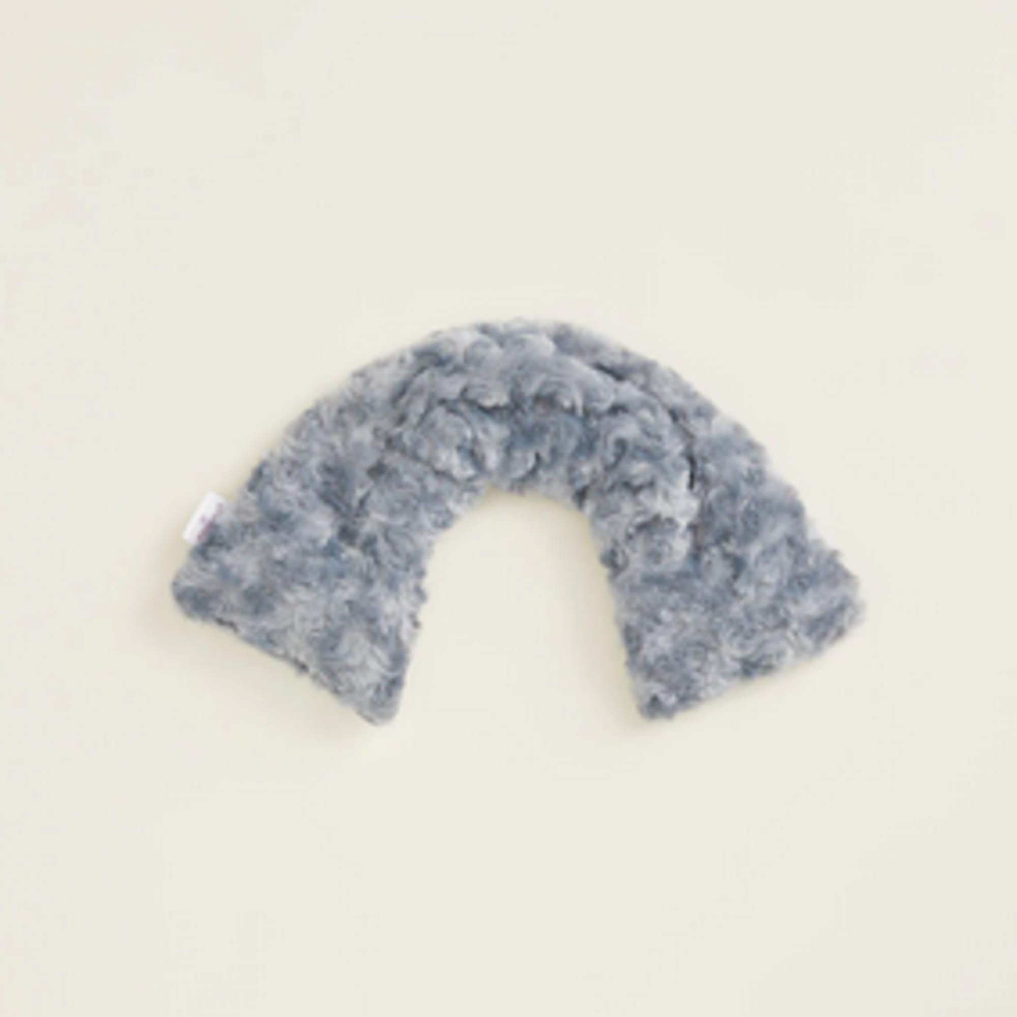 Gray fuzzy U-shaped plush item on a plain background
