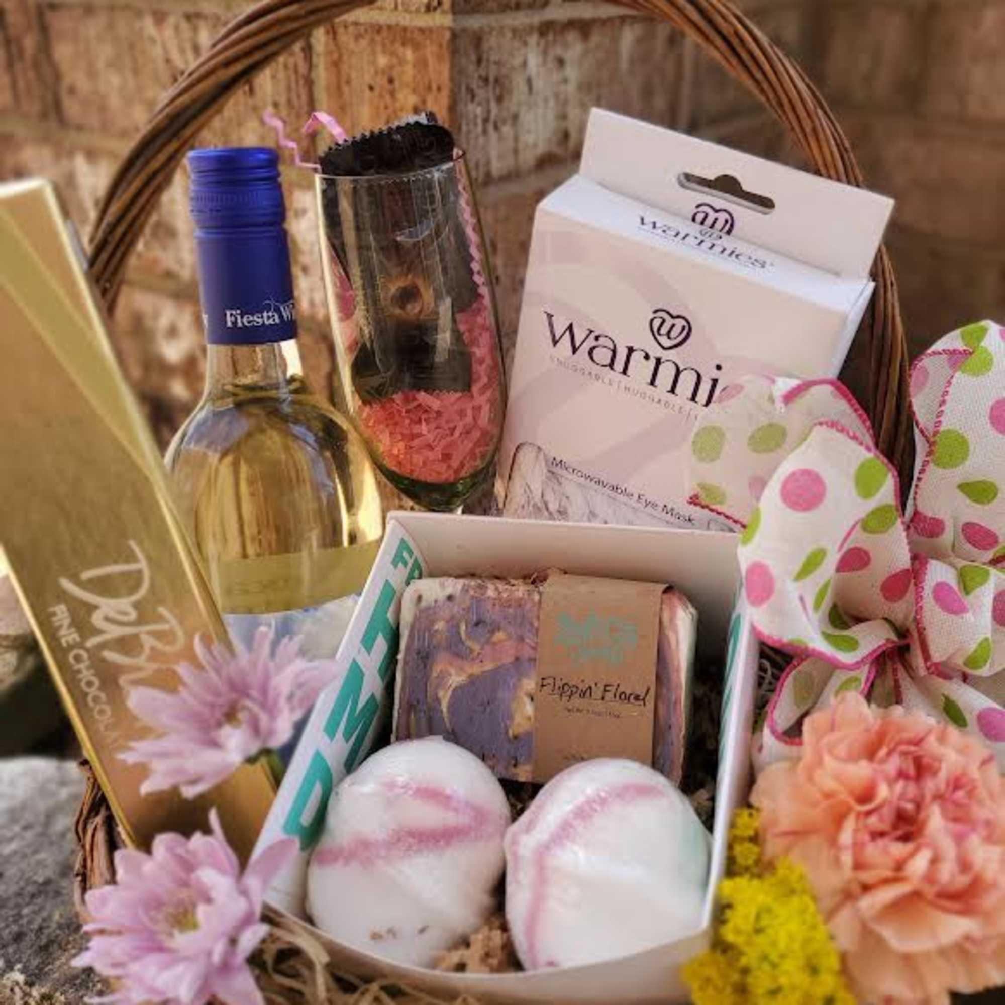Gift basket with wine, chocolates, bath items, and flowers