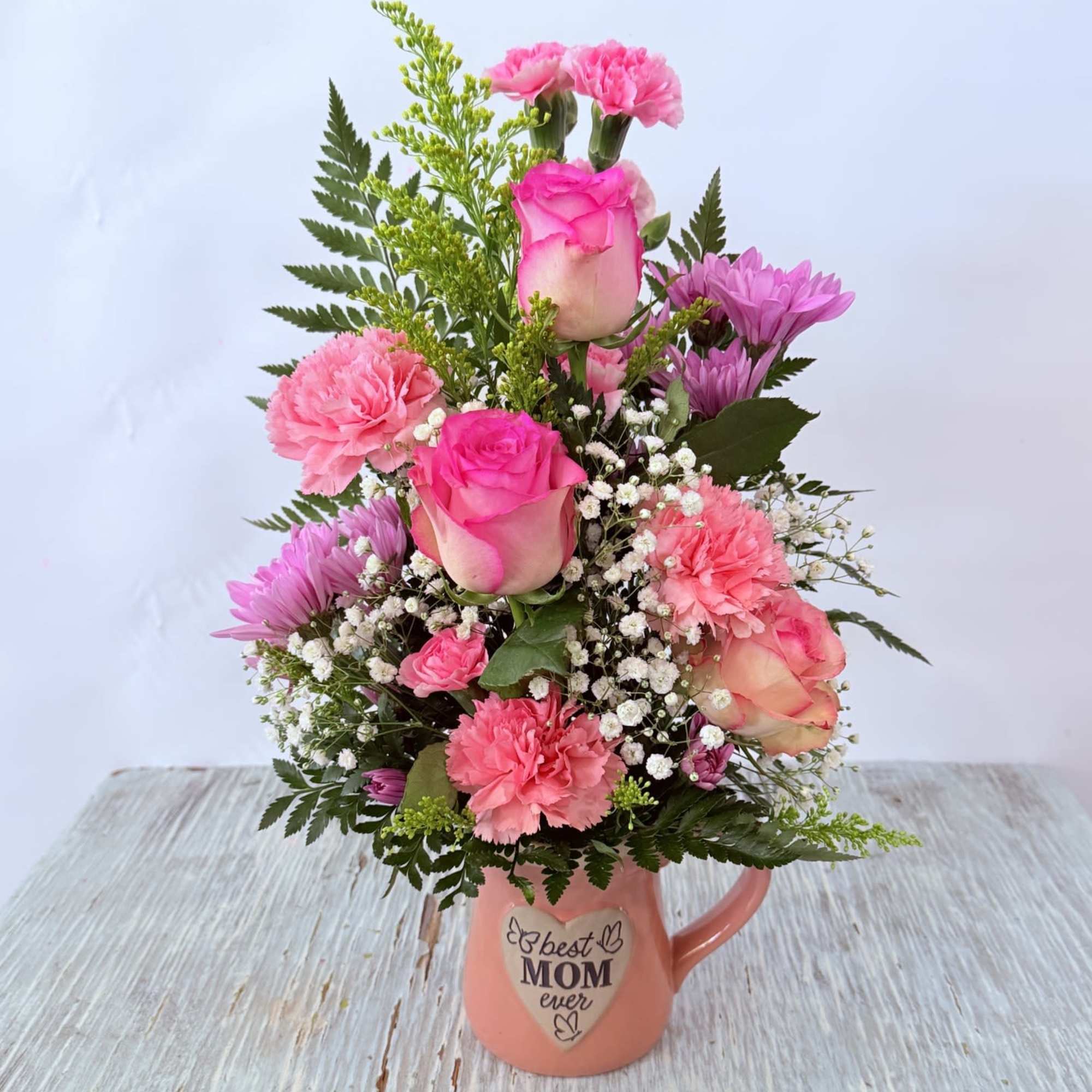 A soft-centered pink rose and ruffled carnations set a tender tone in