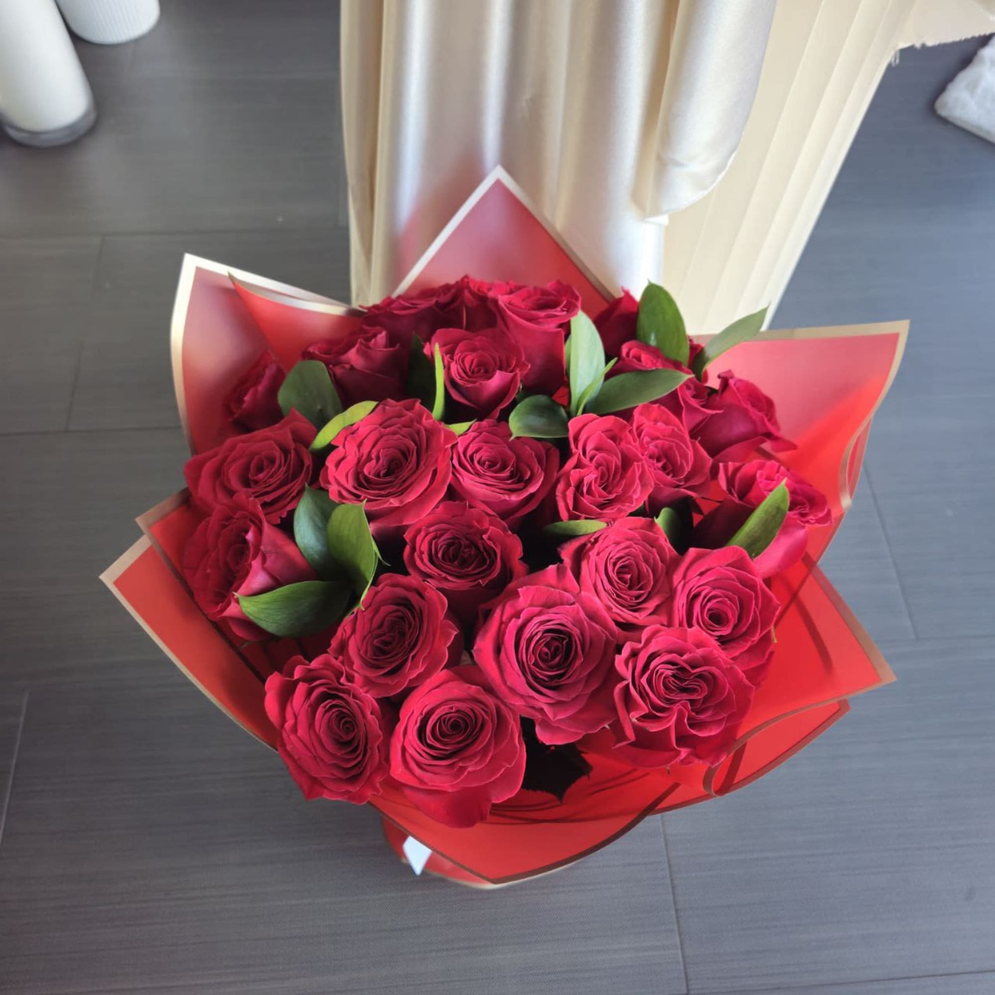 Large bouquet of deep red roses wrapped in red paper