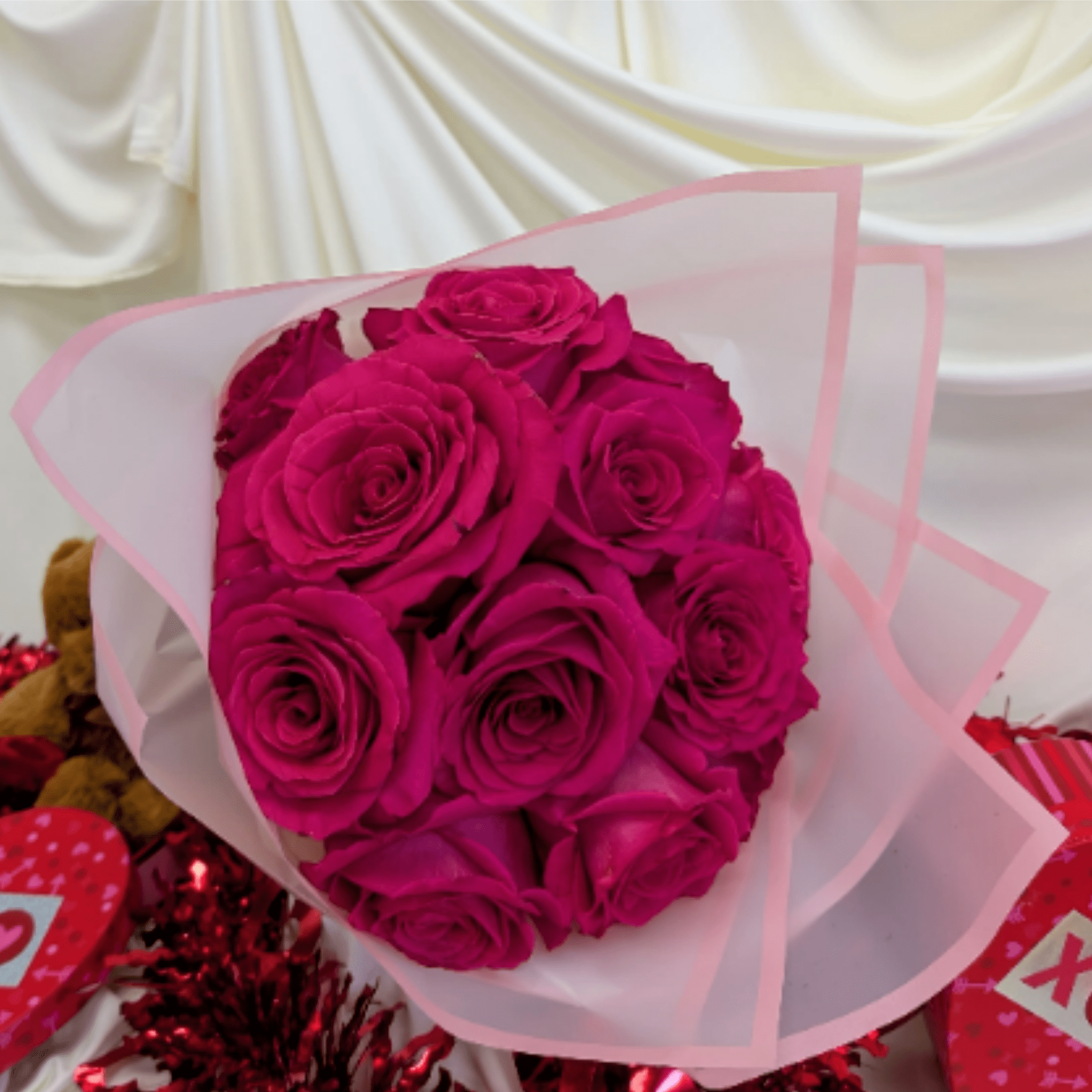 Bouquet of bright pink roses wrapped in pale pink paper