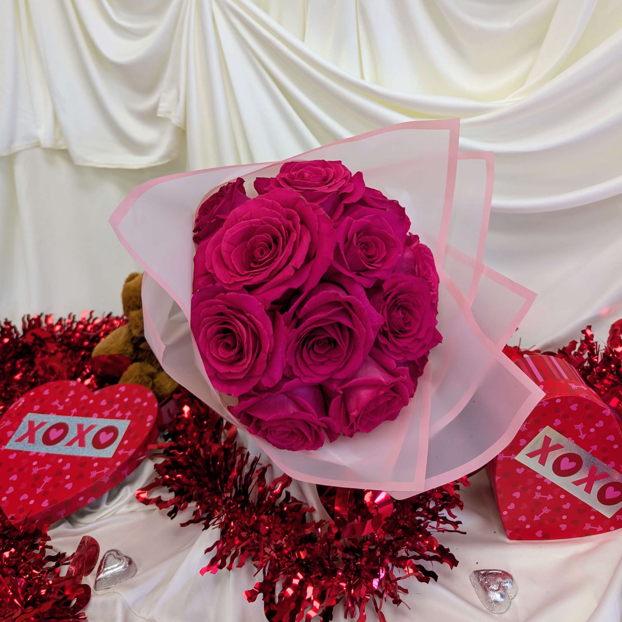 Bouquet of bright pink roses wrapped in pale pink paper