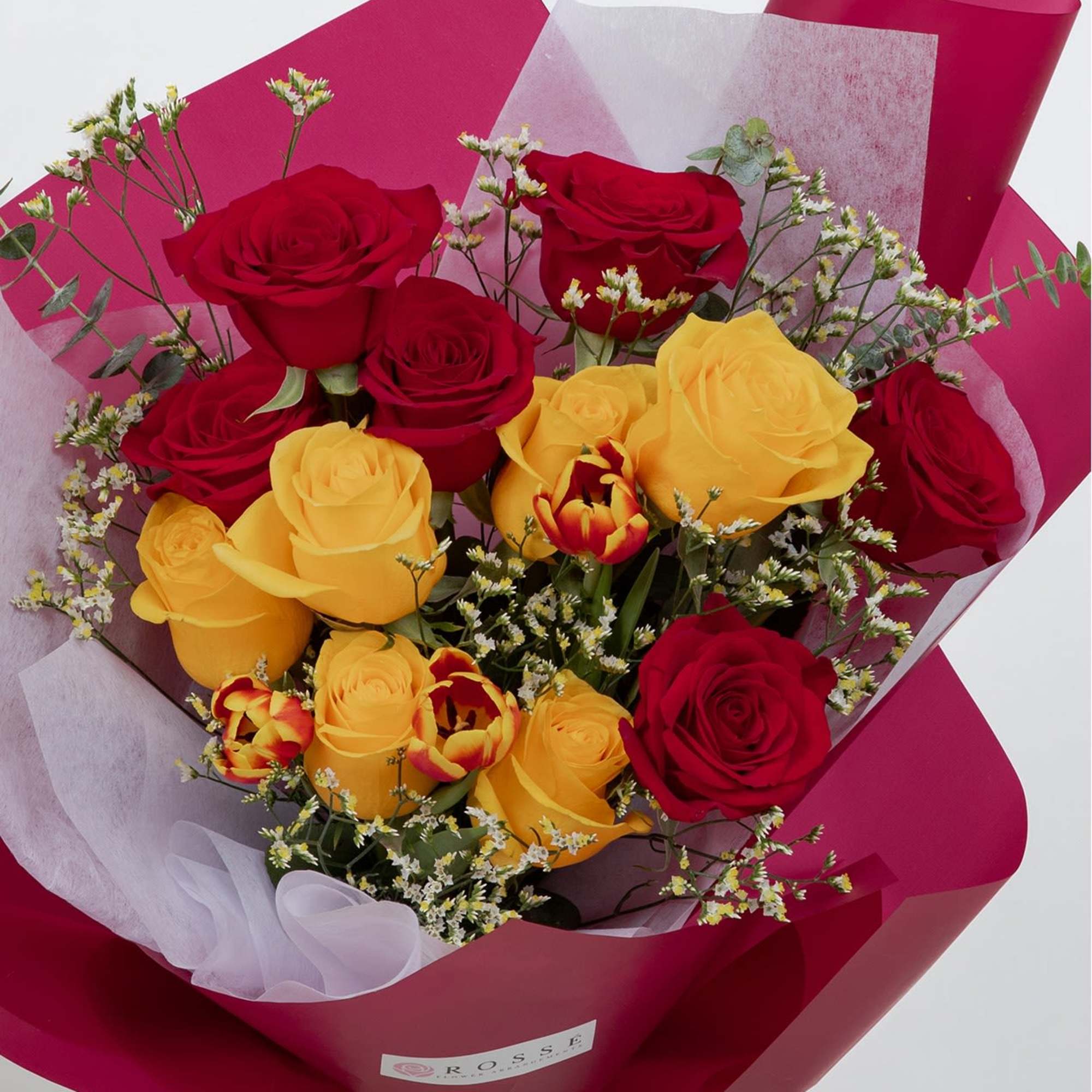 A vibrant bouquet featuring a dozen roses paired with fresh tulips and