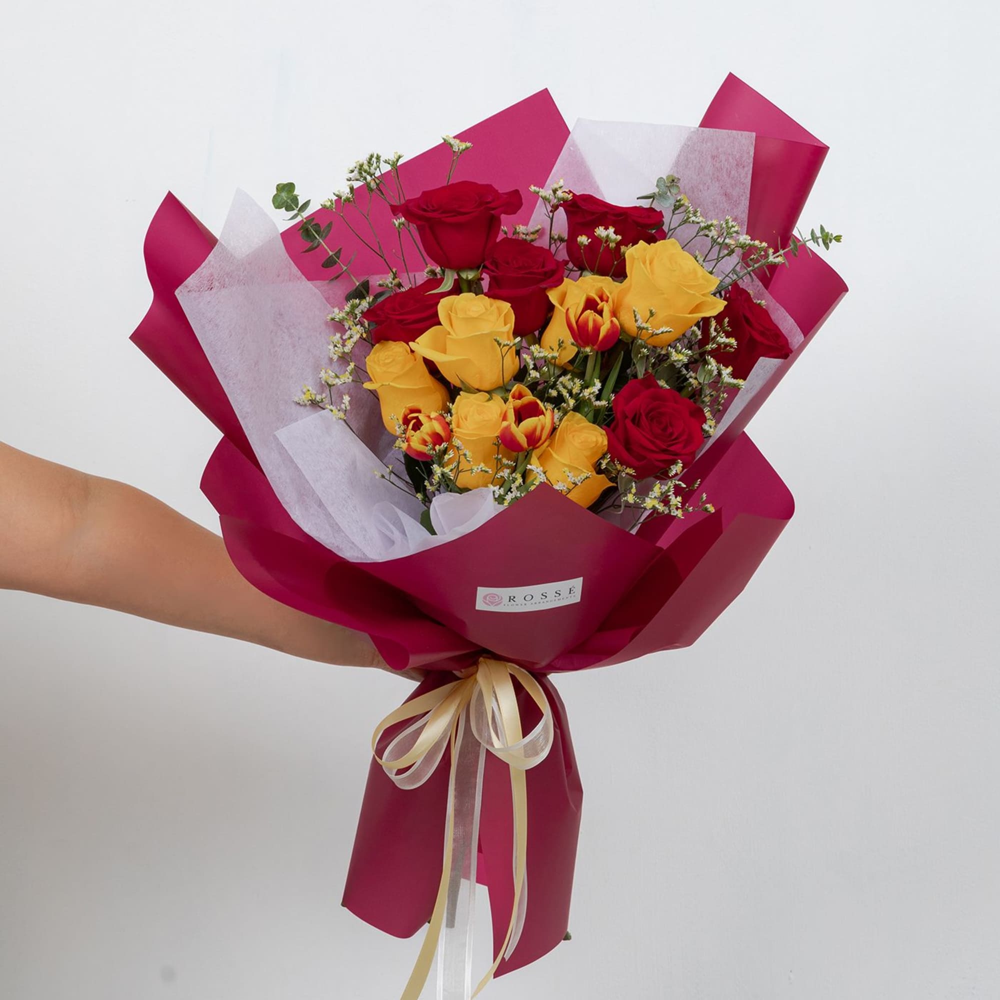 A vibrant bouquet featuring a dozen roses paired with fresh tulips and