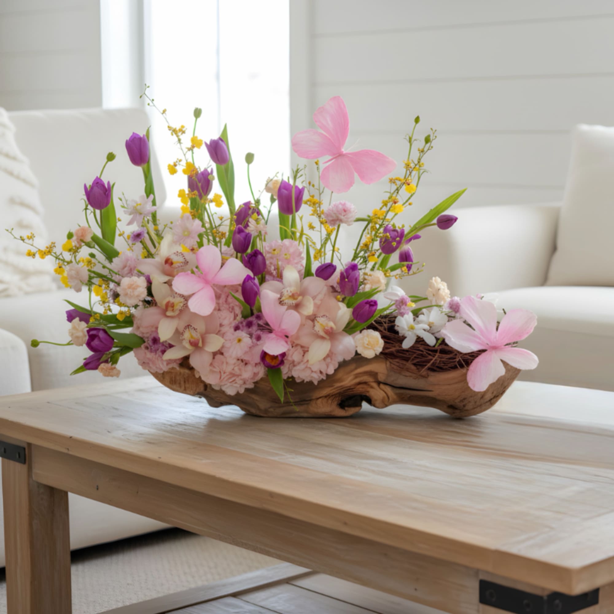 Pink hydrangeas, pink orchids and tulips with sunny yellow accents in a