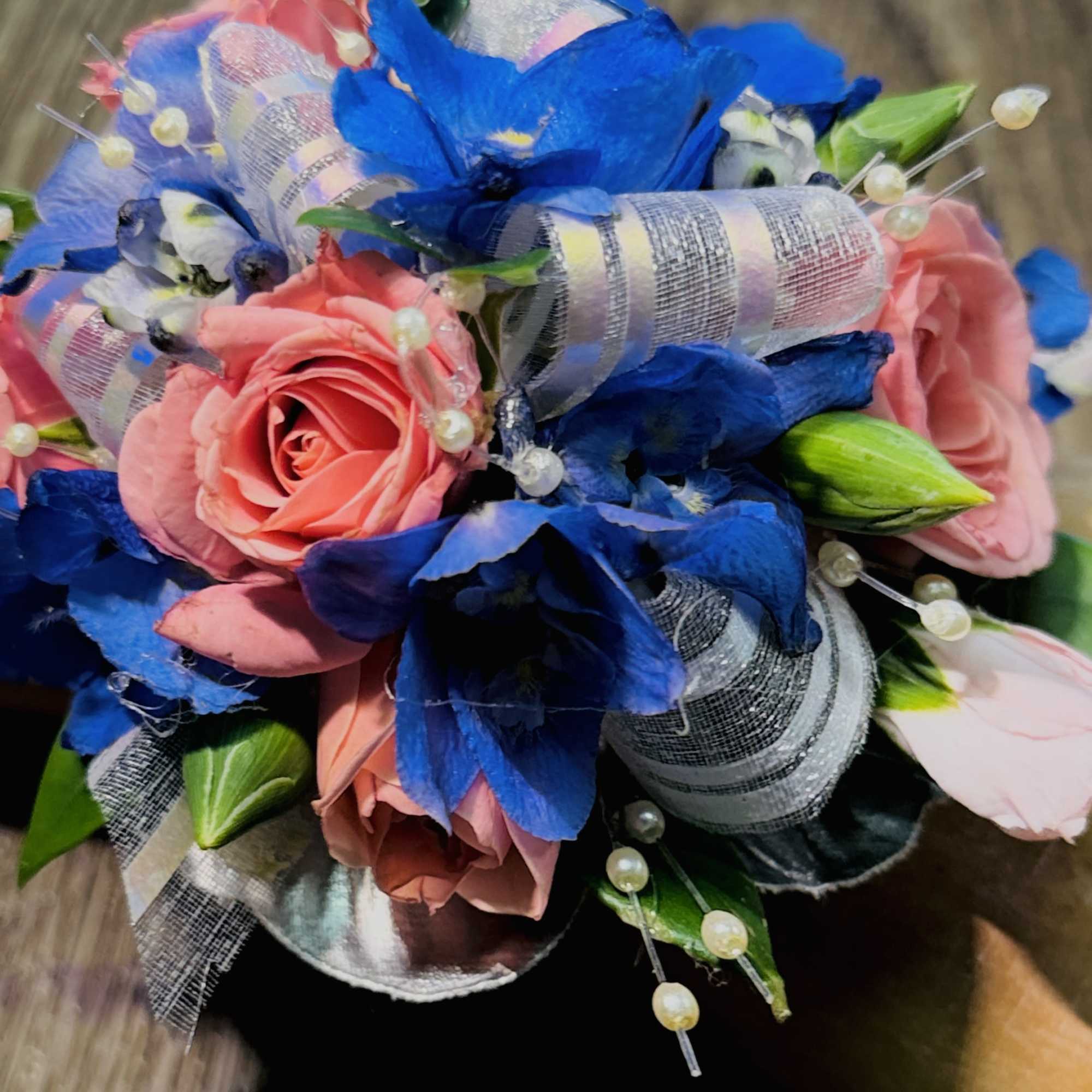 A delicate and romantic corsage featuring soft light pink roses paired with