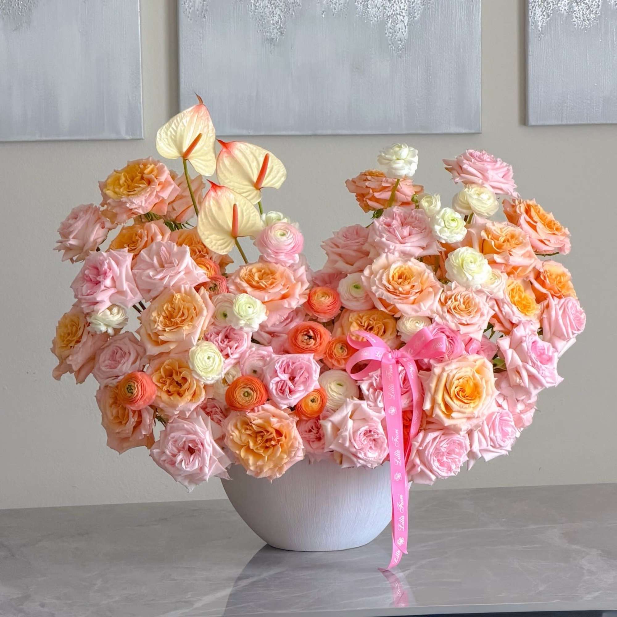 A lush, rounded arrangement in soft blush, peach, cream and pale orange-perfect